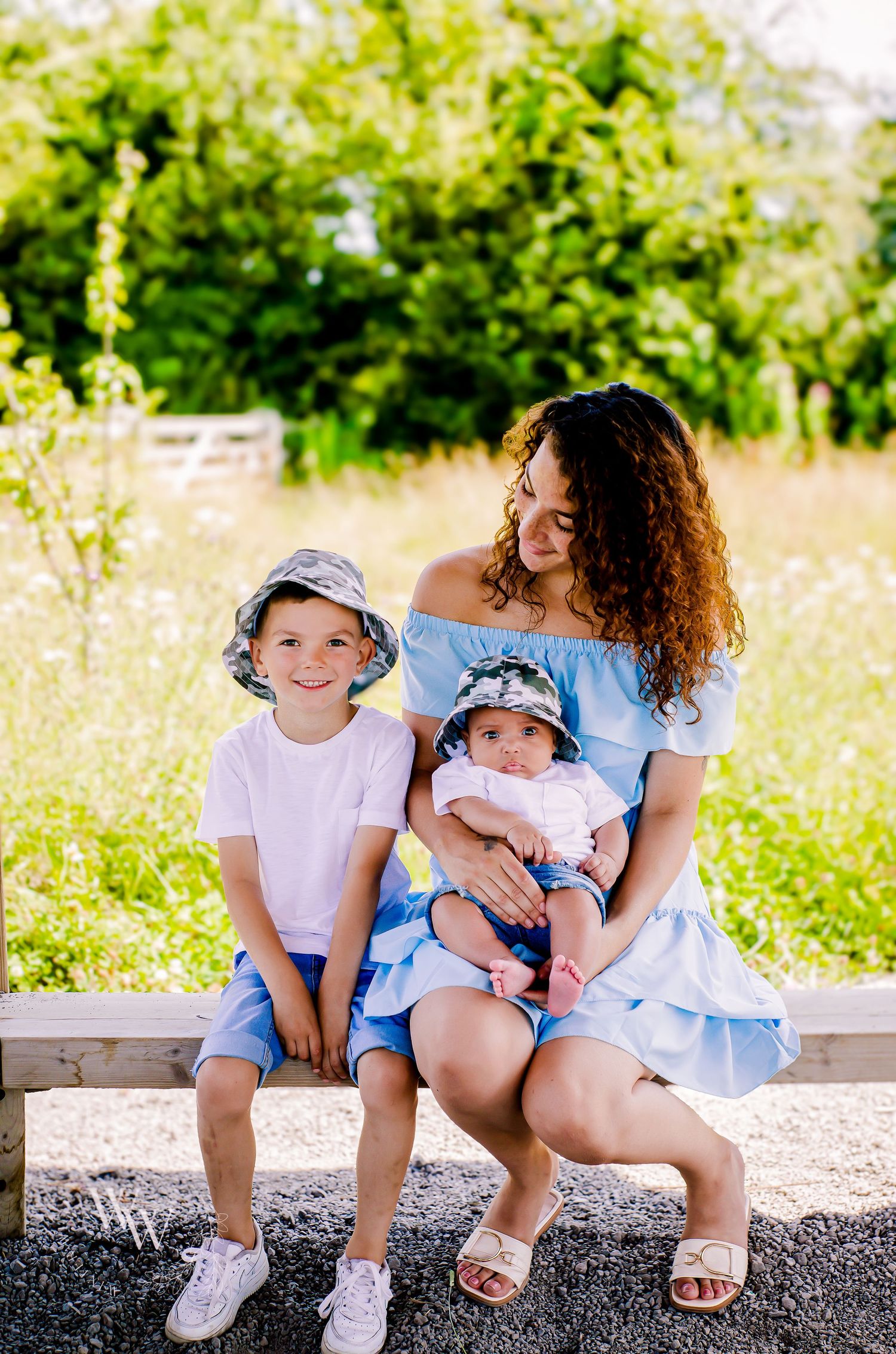 Relaxed portrait of a mother and her two children in the countryside at Cosmeston Lake, Penarth