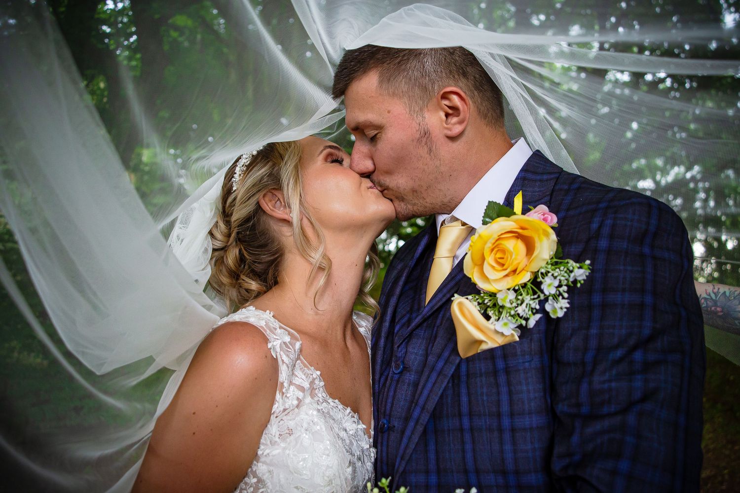 Bride and groom kissing beneath a softly draped wedding veil at Ridgeway Golf Club