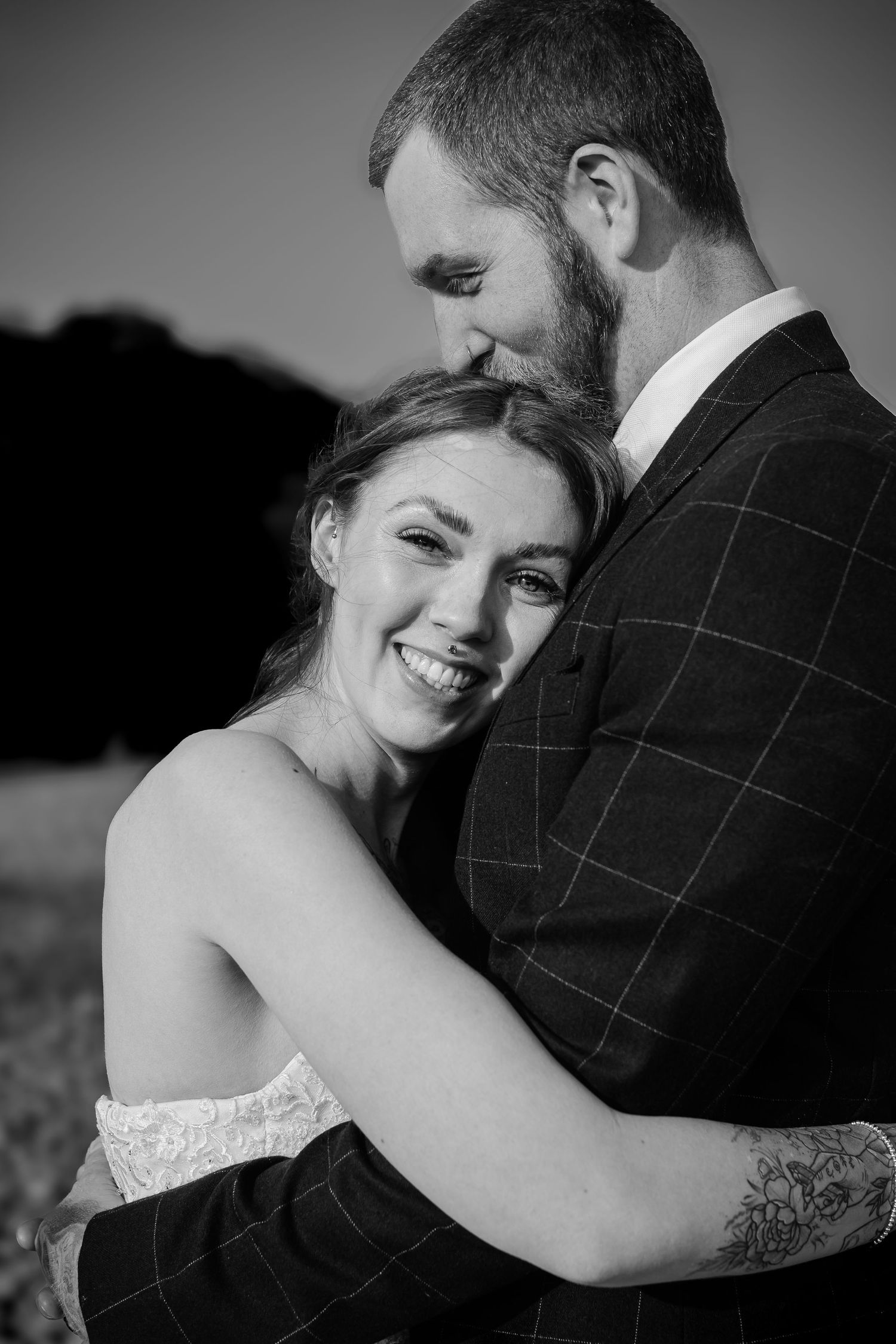 Black-and-white portrait of the bride cuddling her groom