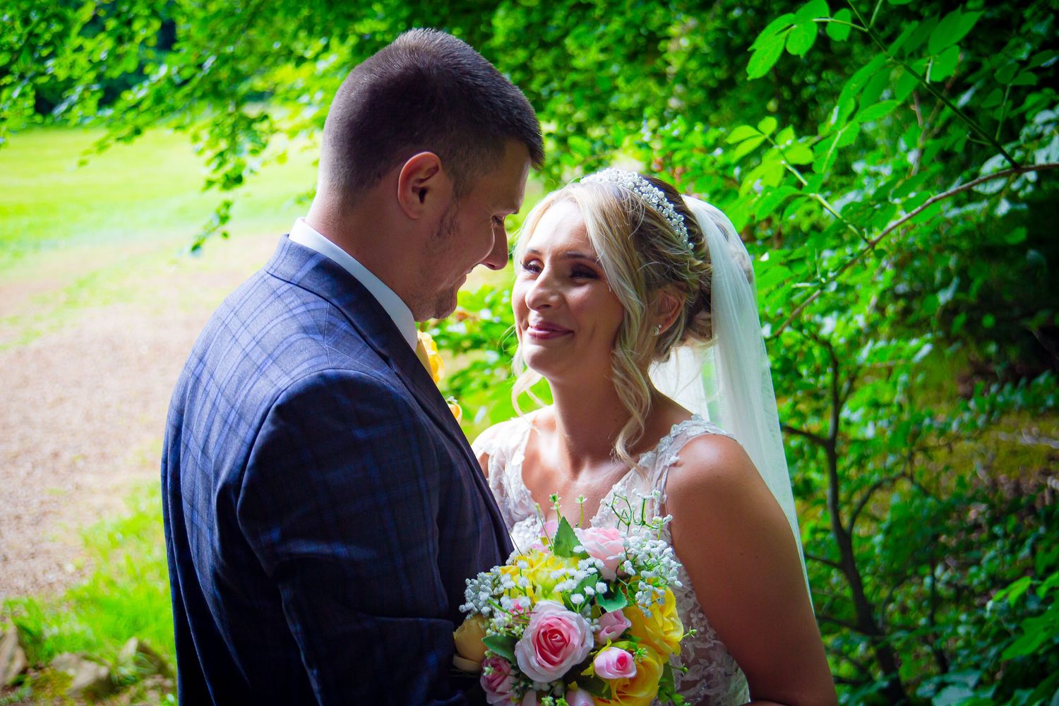 Bride smiling at her groom while holding a colourful wedding bouquet at Ridgeway Golf Club