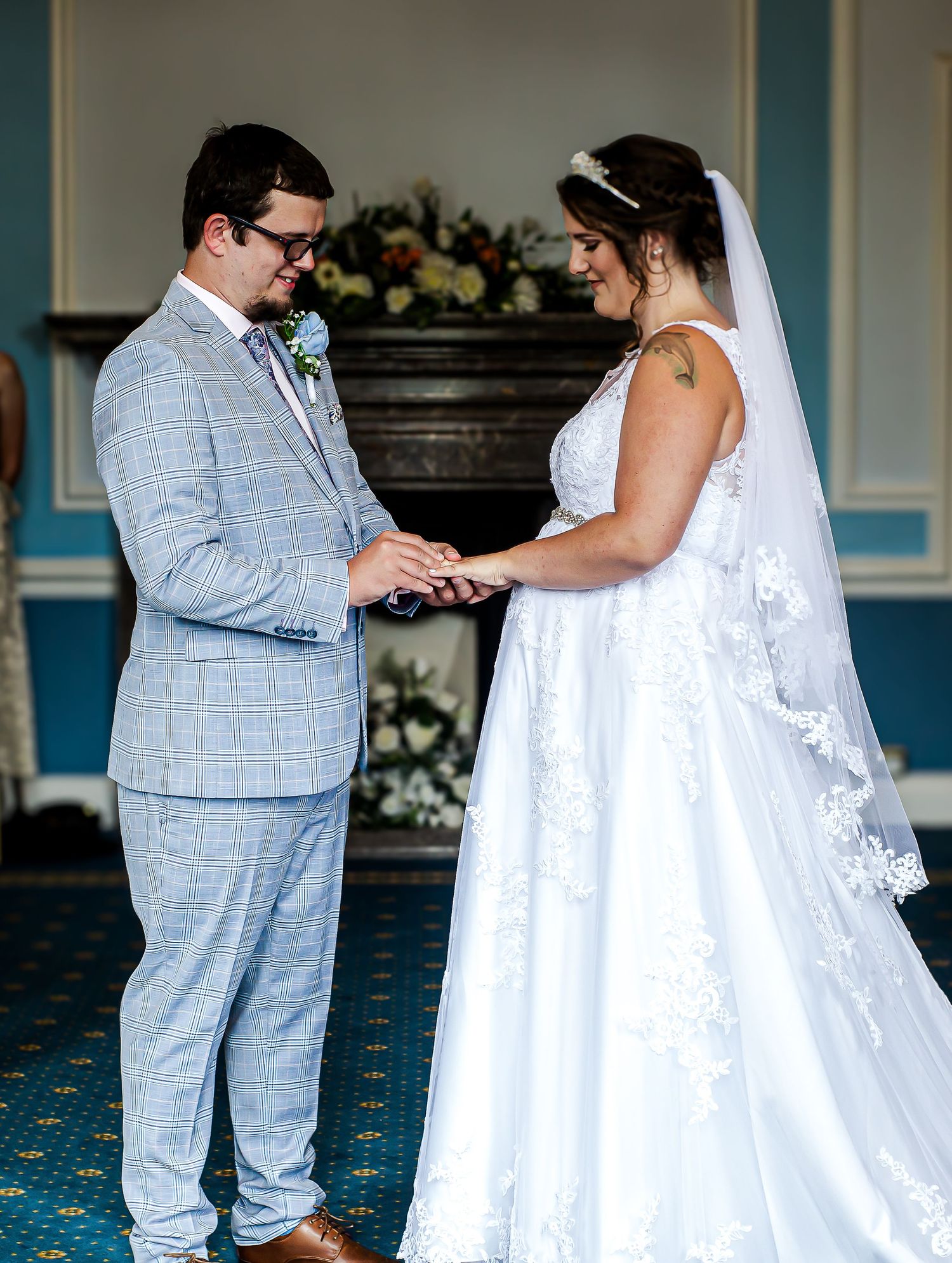 Bride placing the wedding ring on the groom’s finger at Cardiff City Hall