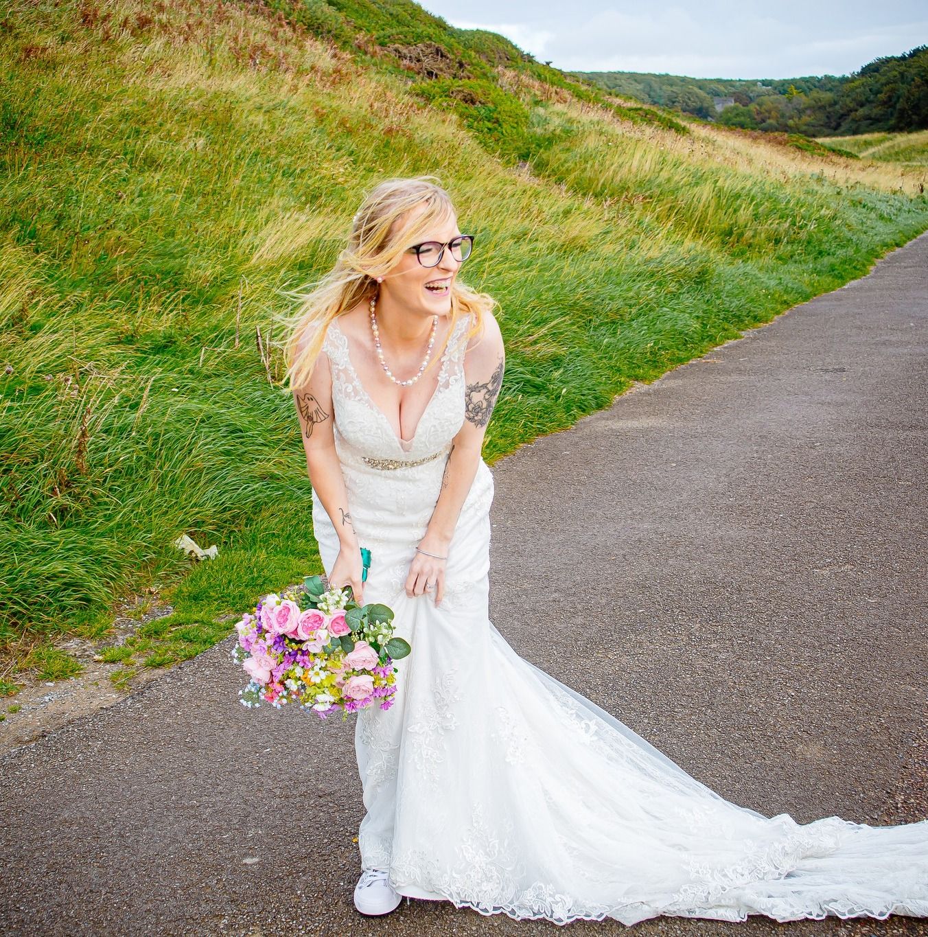 Portrait of bride smiling holding wildflowers bouquet at Southendown beach