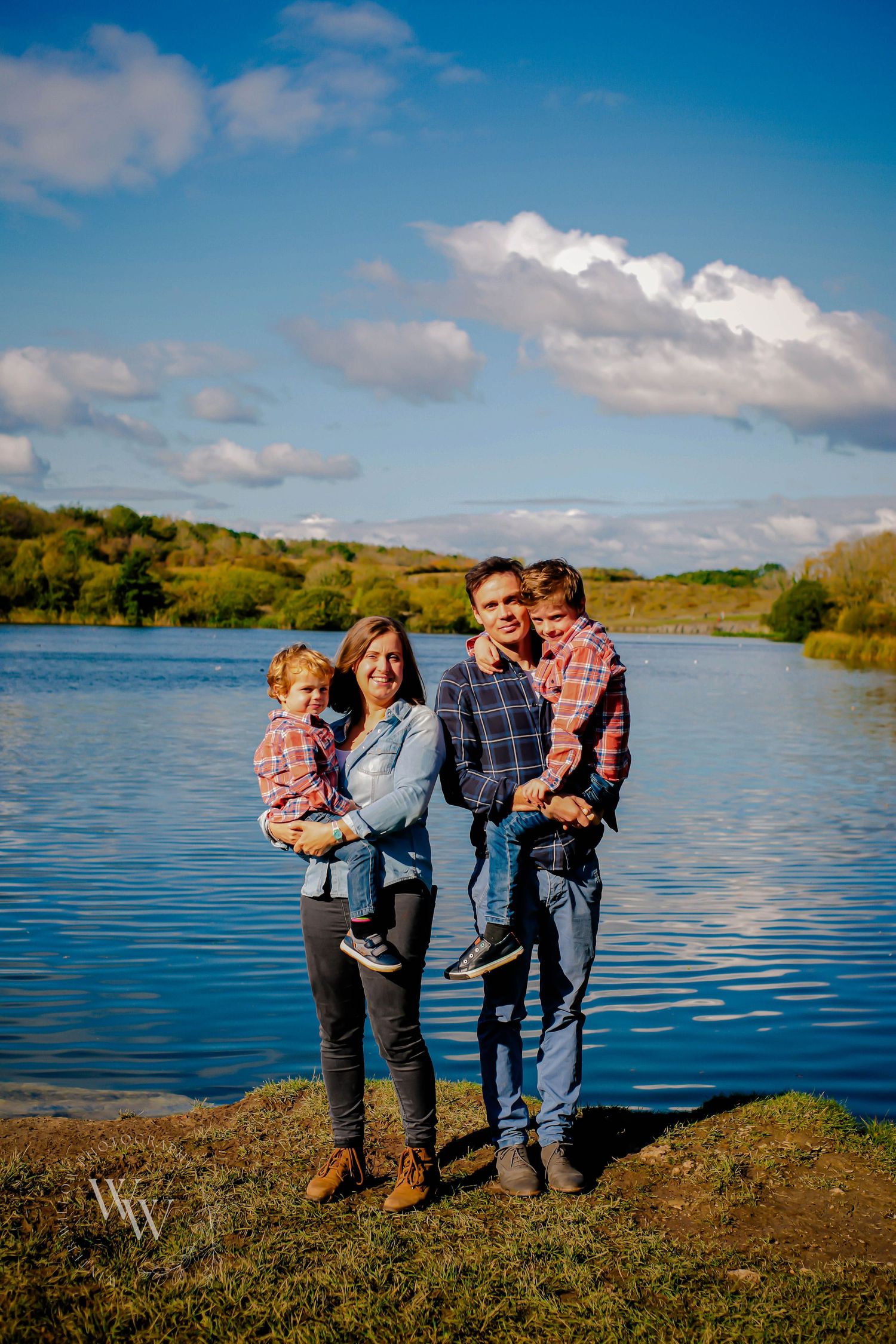 Family of four standing beside the water at Cosmeston Lakes, Penarth