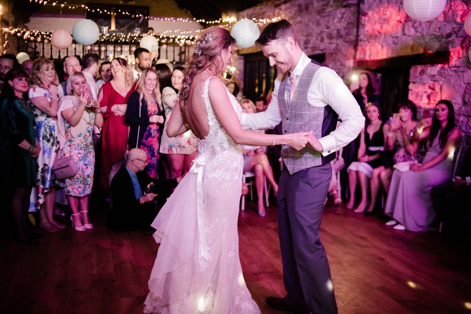 Bride and groom dancing together as their guests watch at Pencoed House