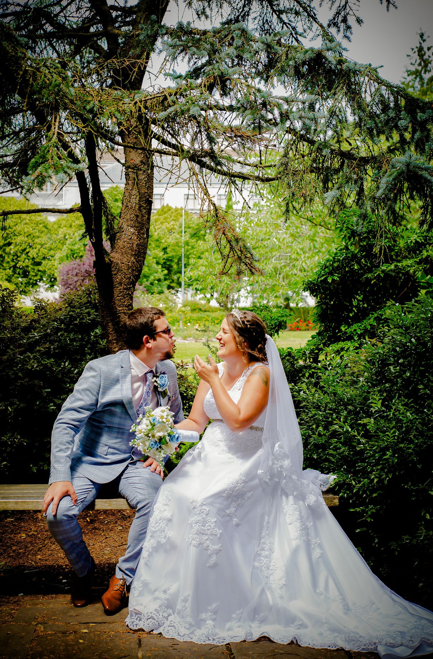 Newlyweds sharing a relaxed moment on a garden bench