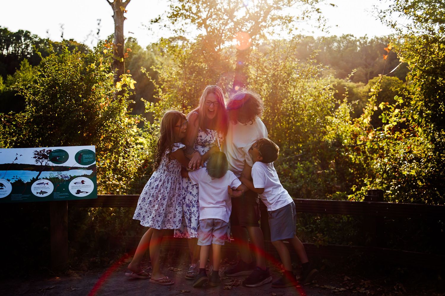 Family sharing a group hug in the golden evening sunlight