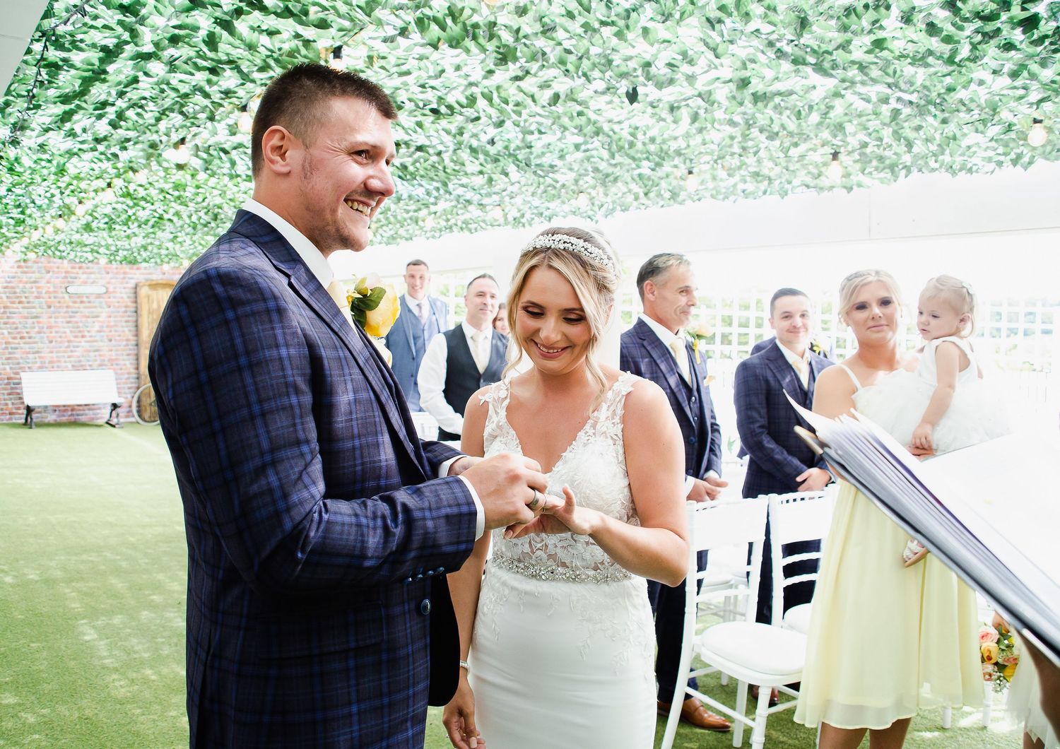 Groom placing a wedding ring on his bride’s finger