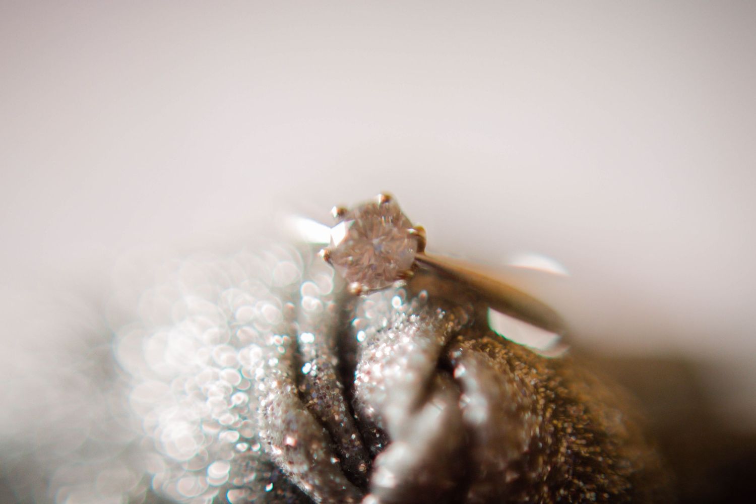 Macro photograph of the bride’s sparkling engagement and wedding rings