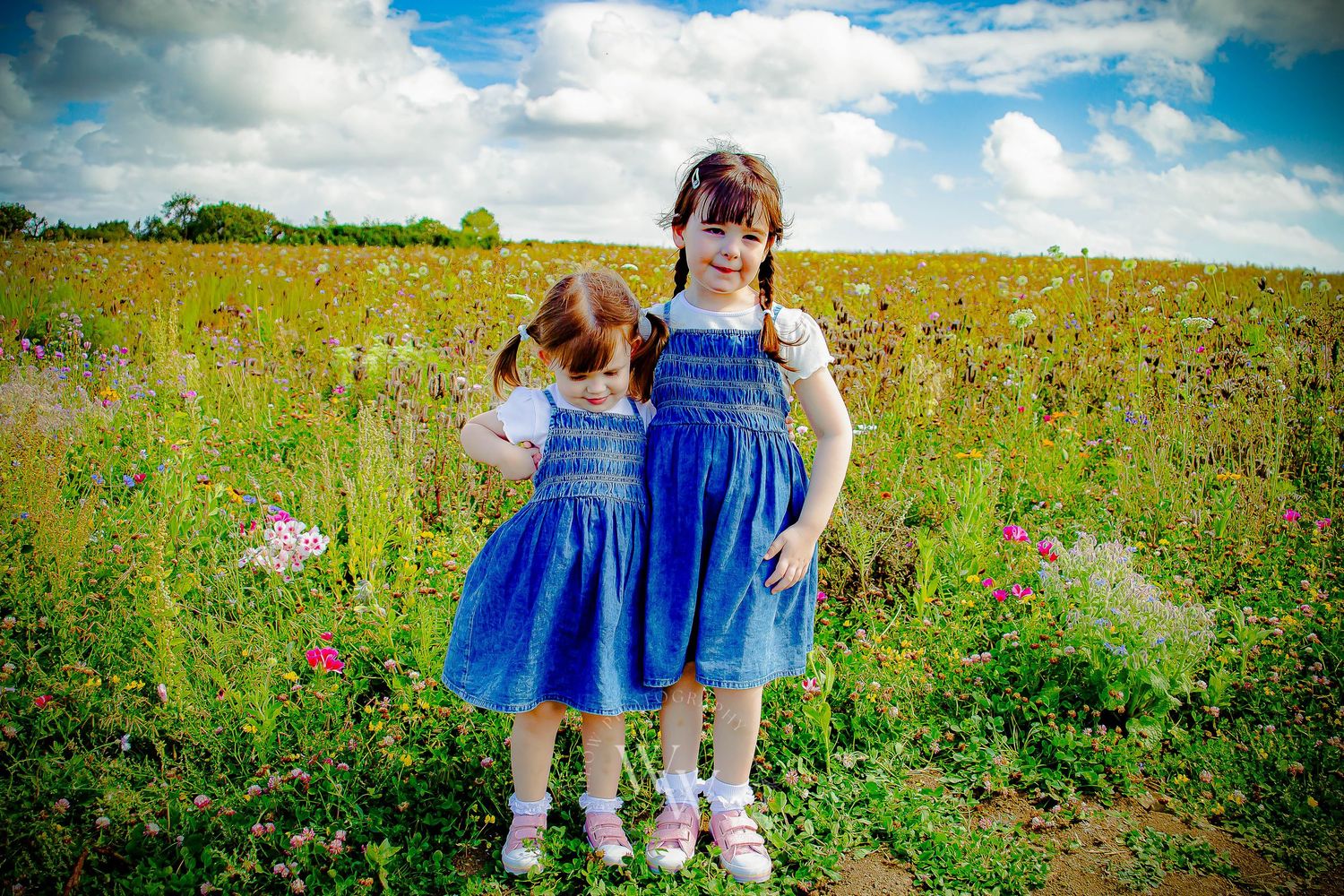 Two sisters standing together in a wildflower field at Rosedew Farm