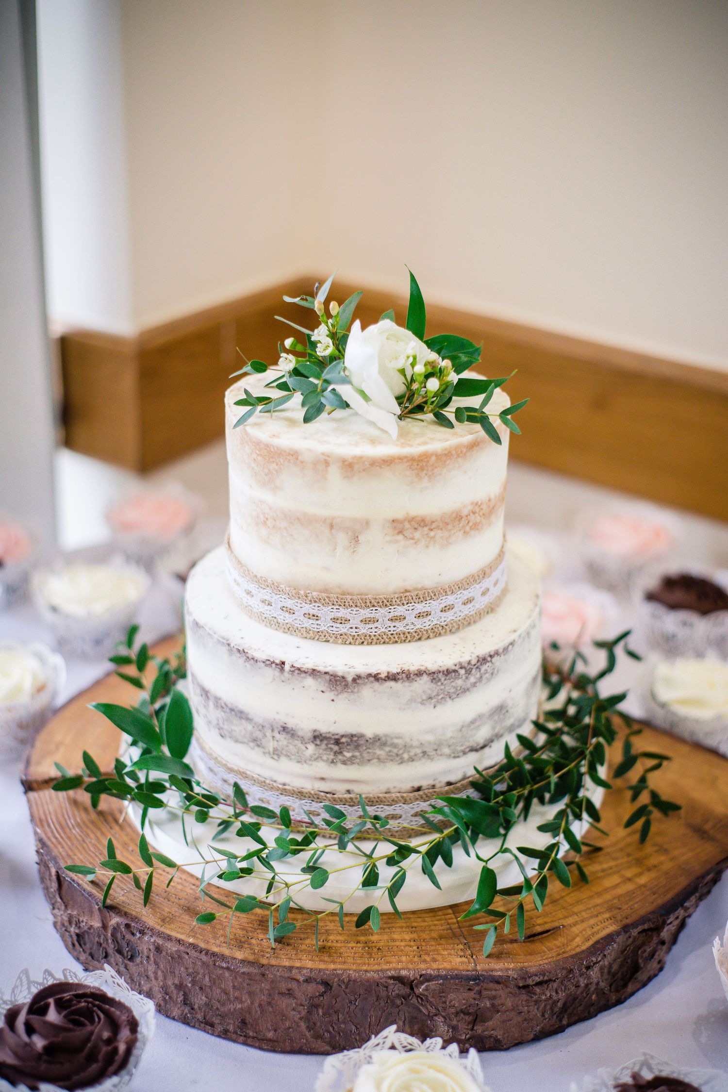 Rustic white wedding cake decorated with greenery at Canada Lodge, Cardiff