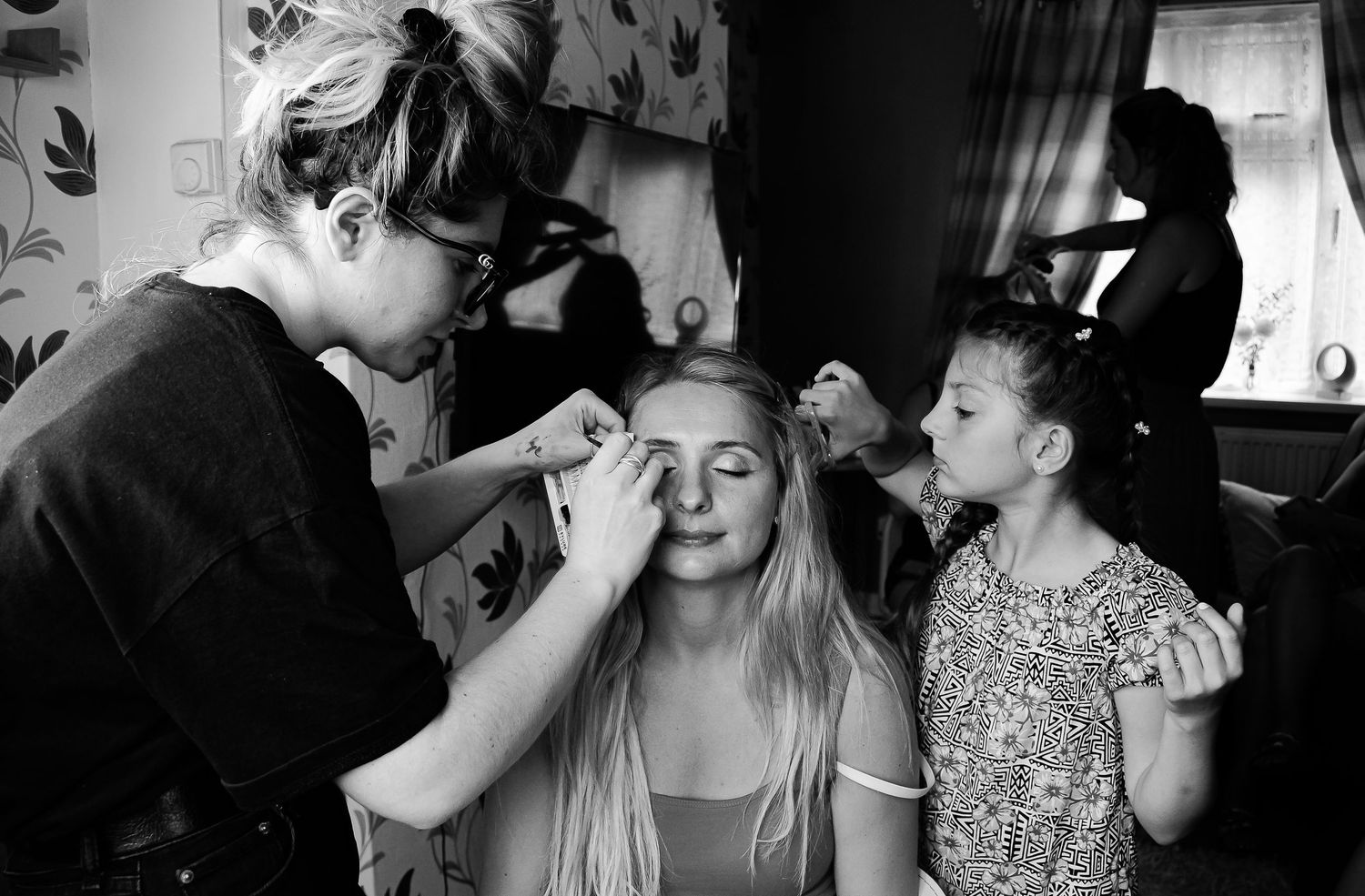 Young girl watching as the bride has her wedding makeup applied