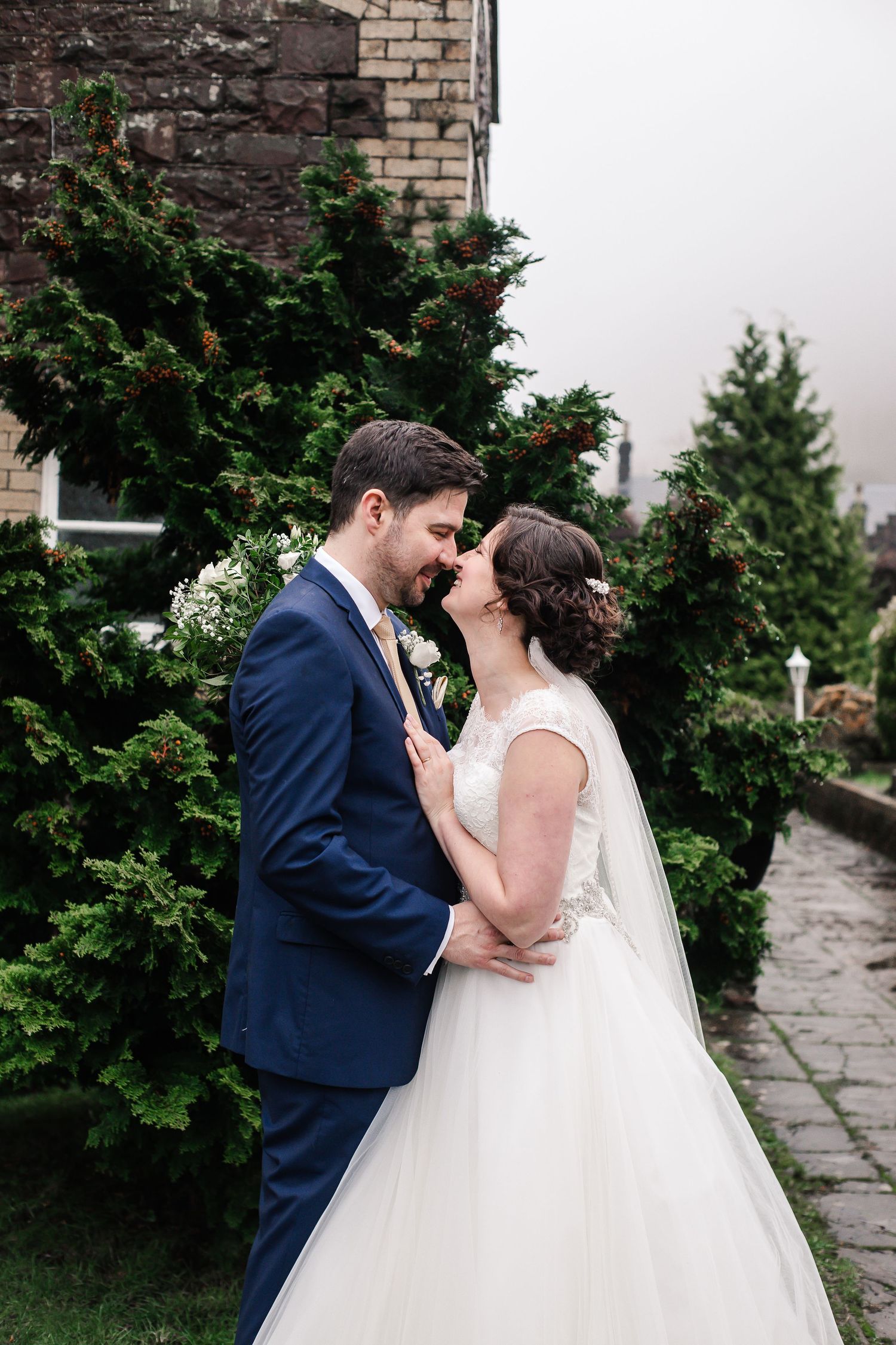 Bride and groom sharing a kiss in the Craig y Nos Castle gardens