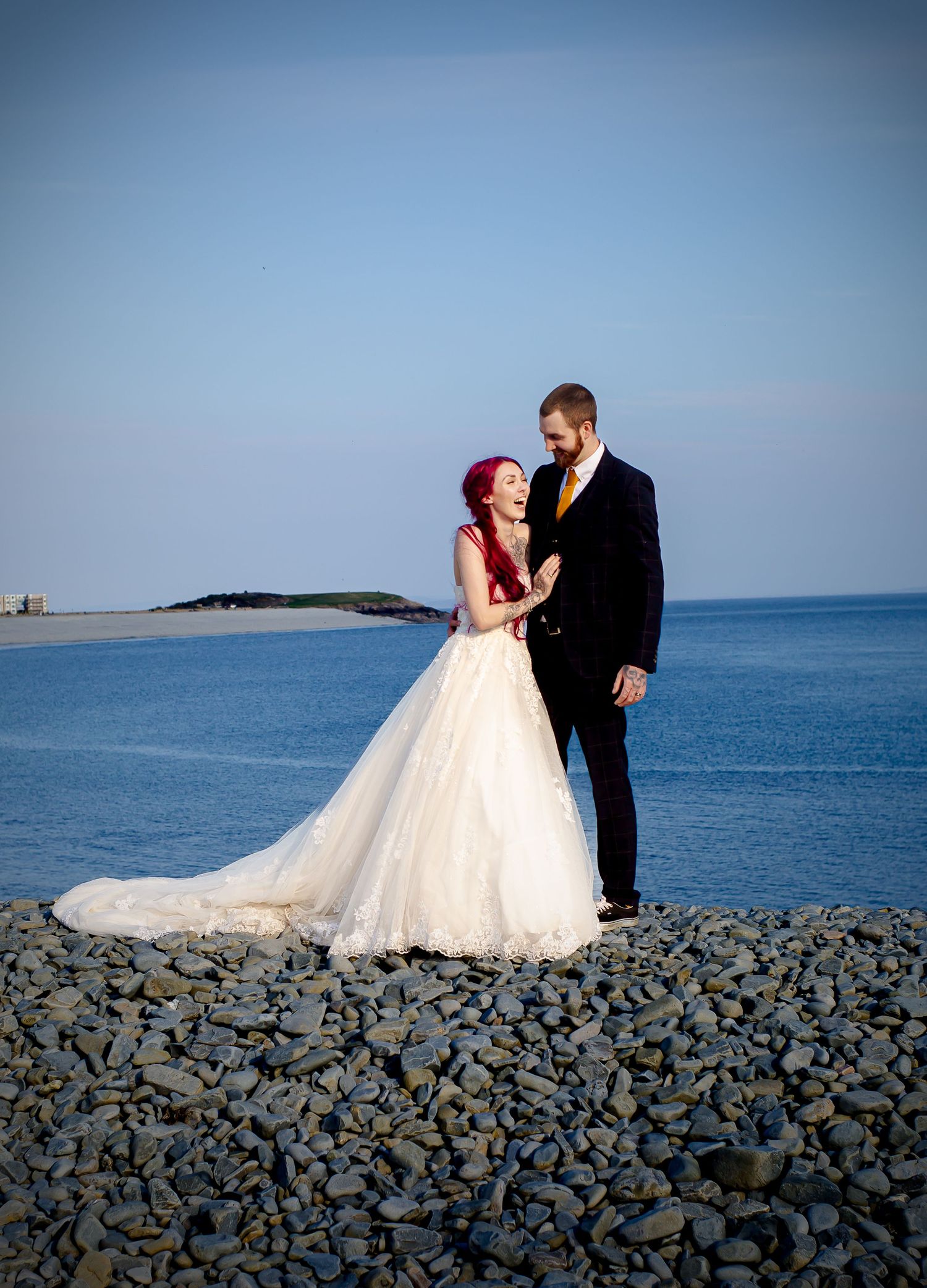 Newlyweds sharing a quiet embrace beside the sea