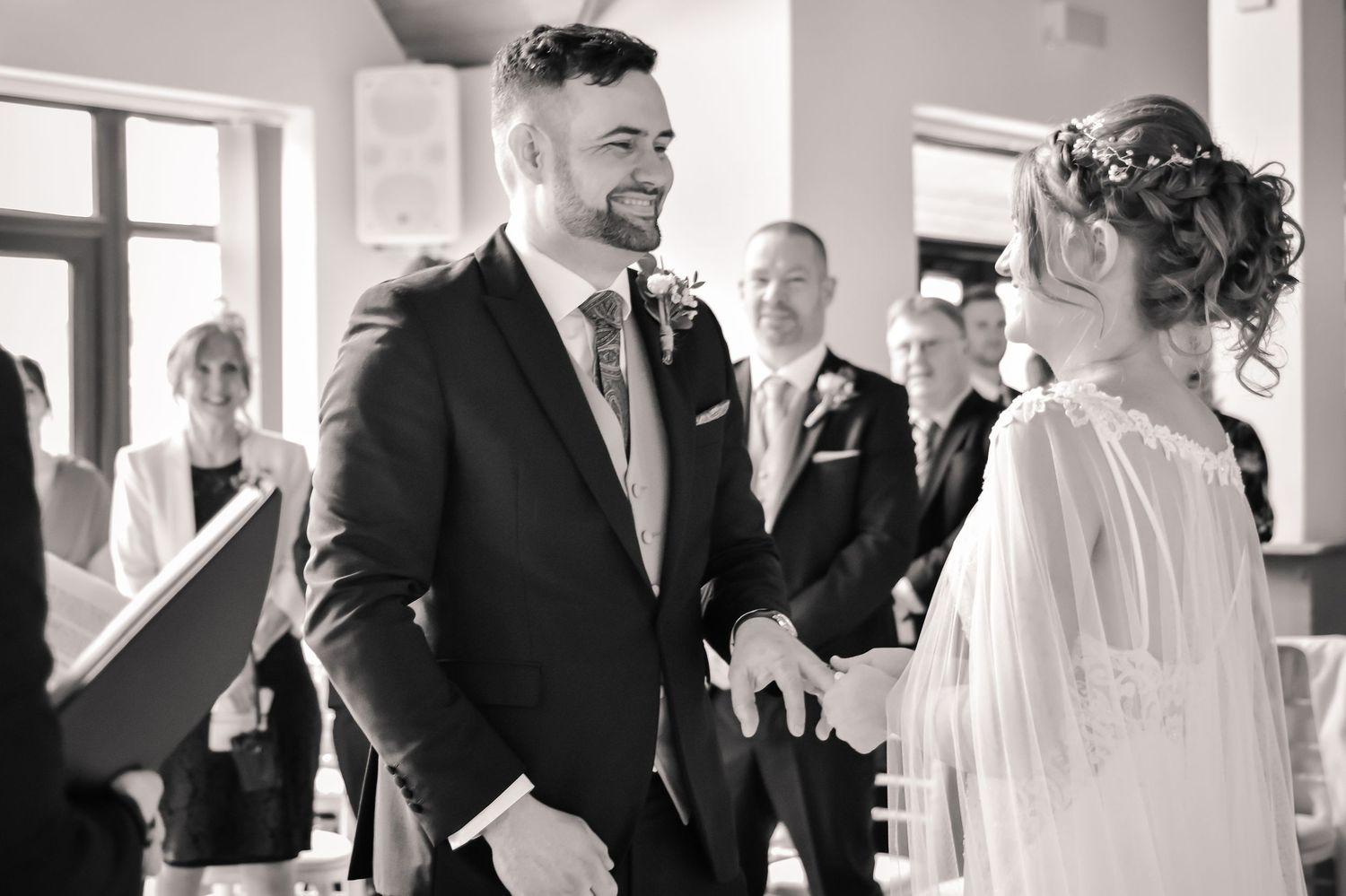 Groom looking emotional as his bride stands opposite him during the ceremony