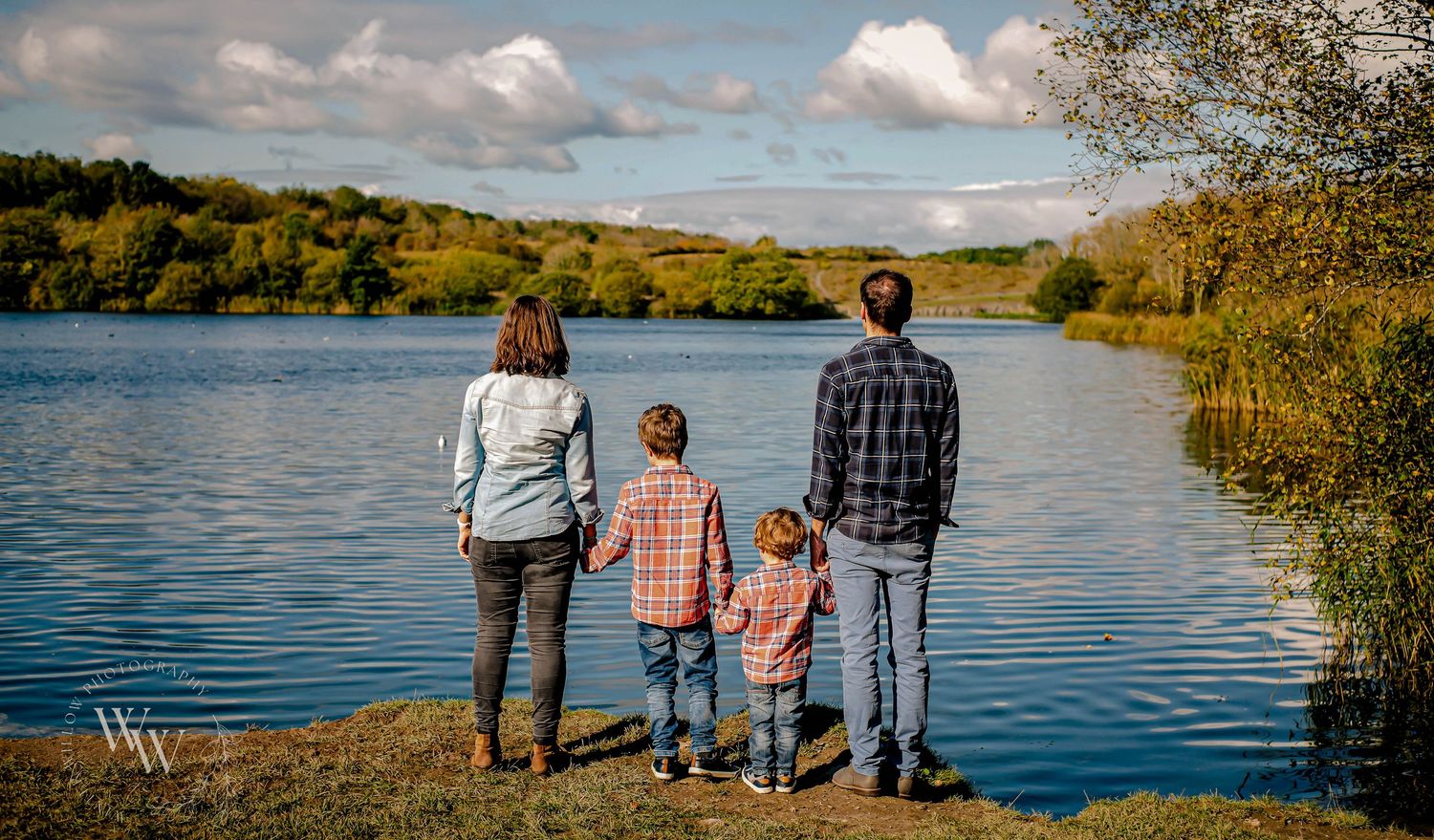 Family looking across the lake during an autumn photoshoot at Cosmeston Lakes