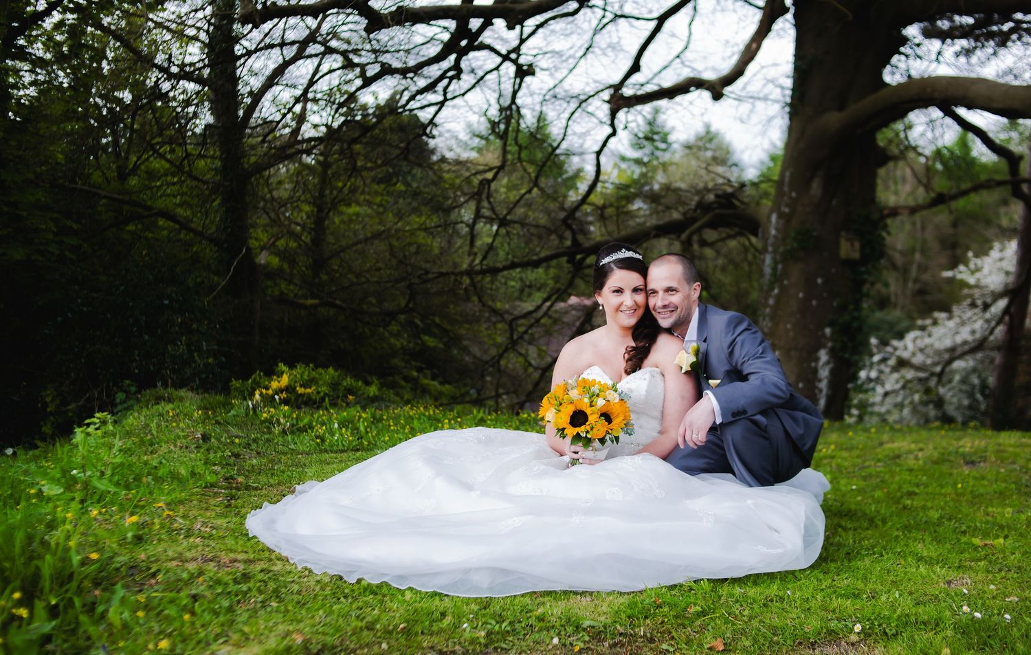 Bride and groom sitting with garden backdrop, Court Colmon, Bridgend