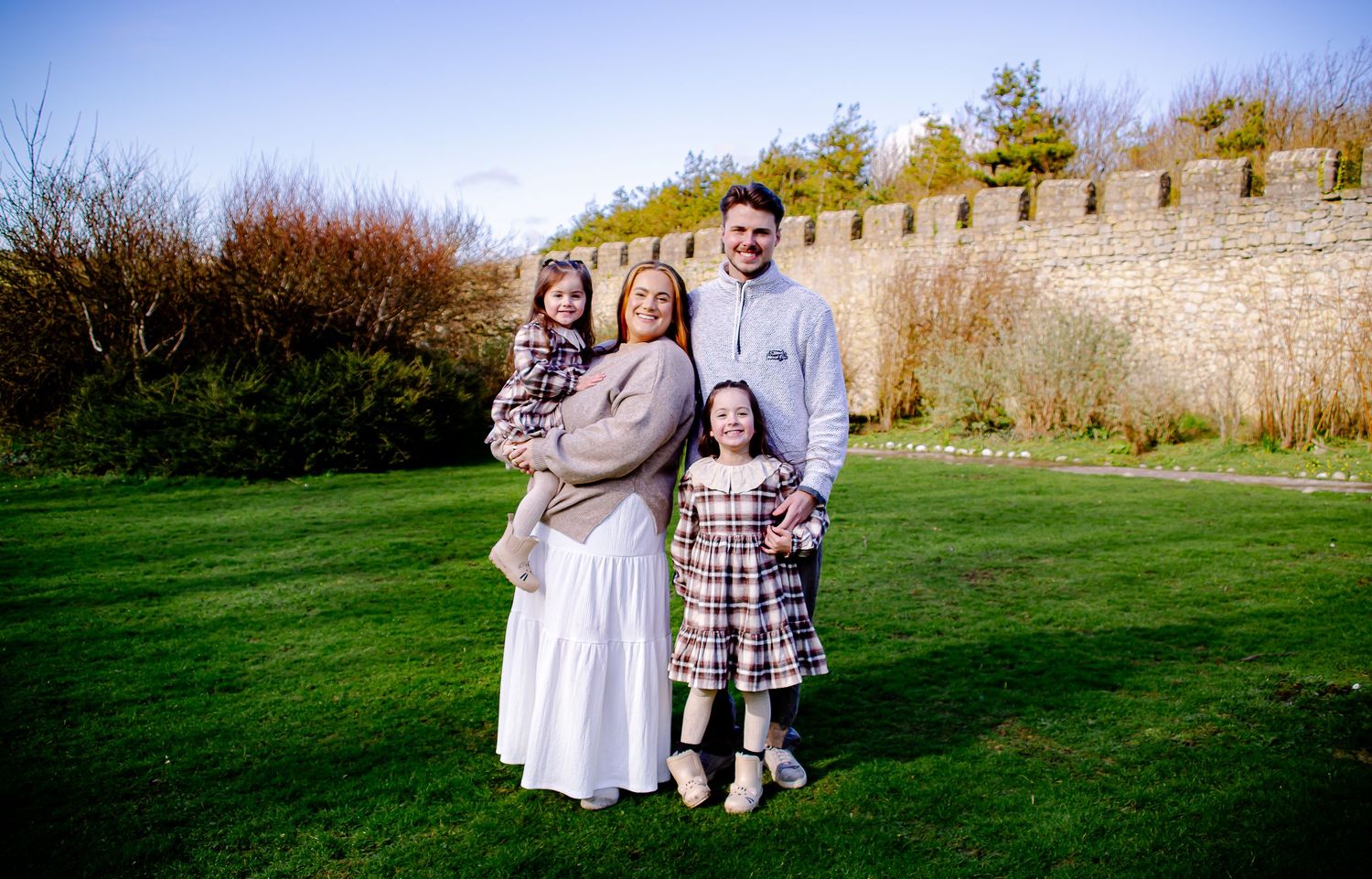 Parents and two daughters smiling together during their family portrait