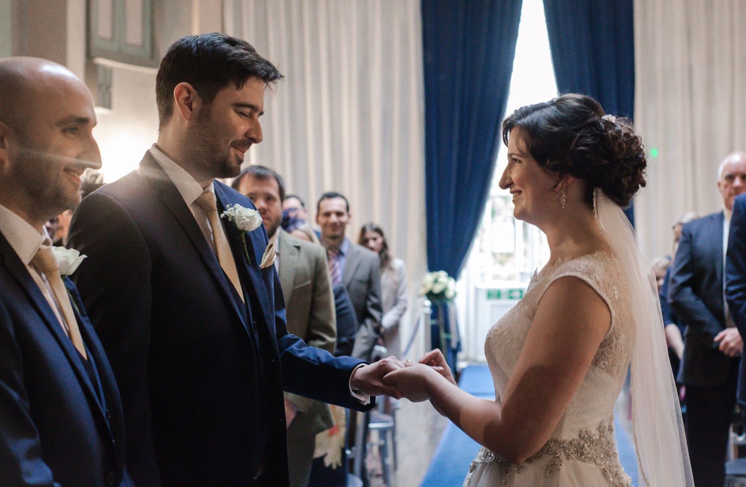 Bride placing a wedding ring on the groom’s finger inside Craig y Nos Castle