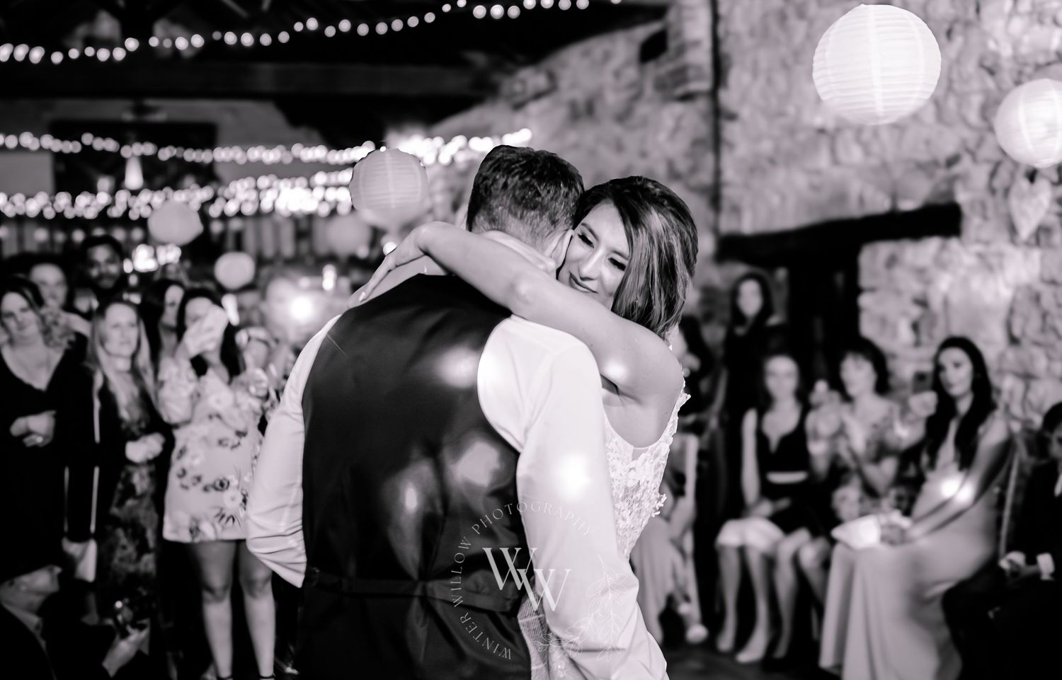 Black and white photograph of the newlyweds embracing during their first dance