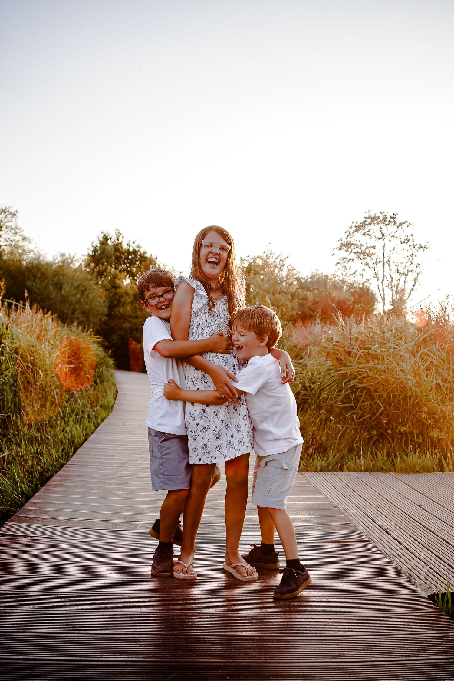 Mother walking playfully with her children along the wooden boardwalk