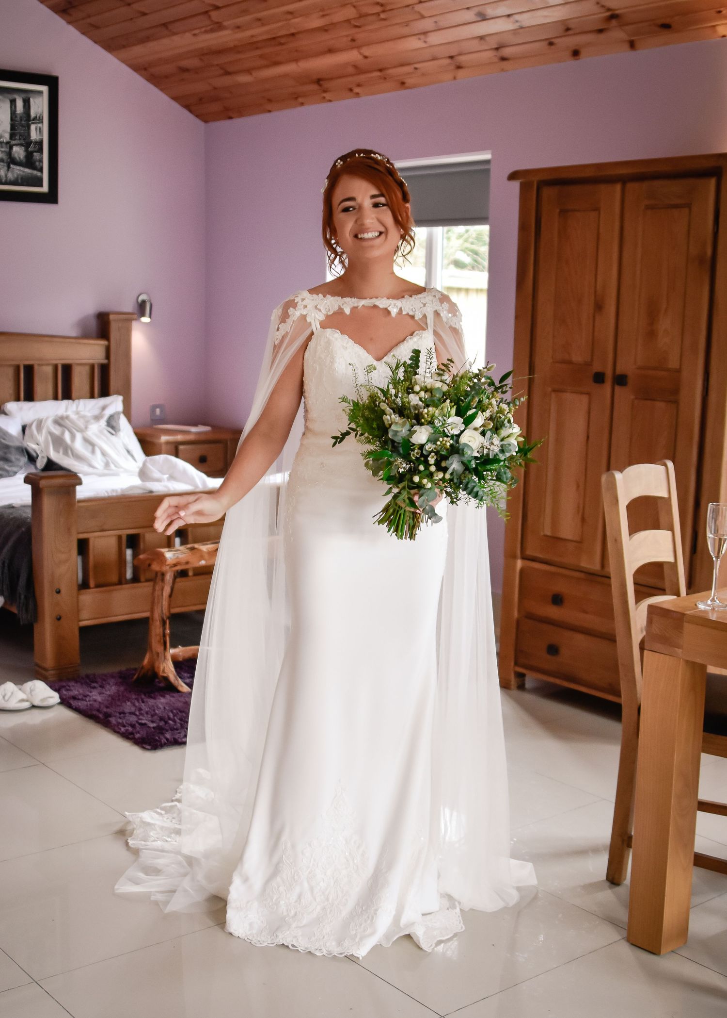 Full-length bridal portrait with a white and green bouquet before the wedding