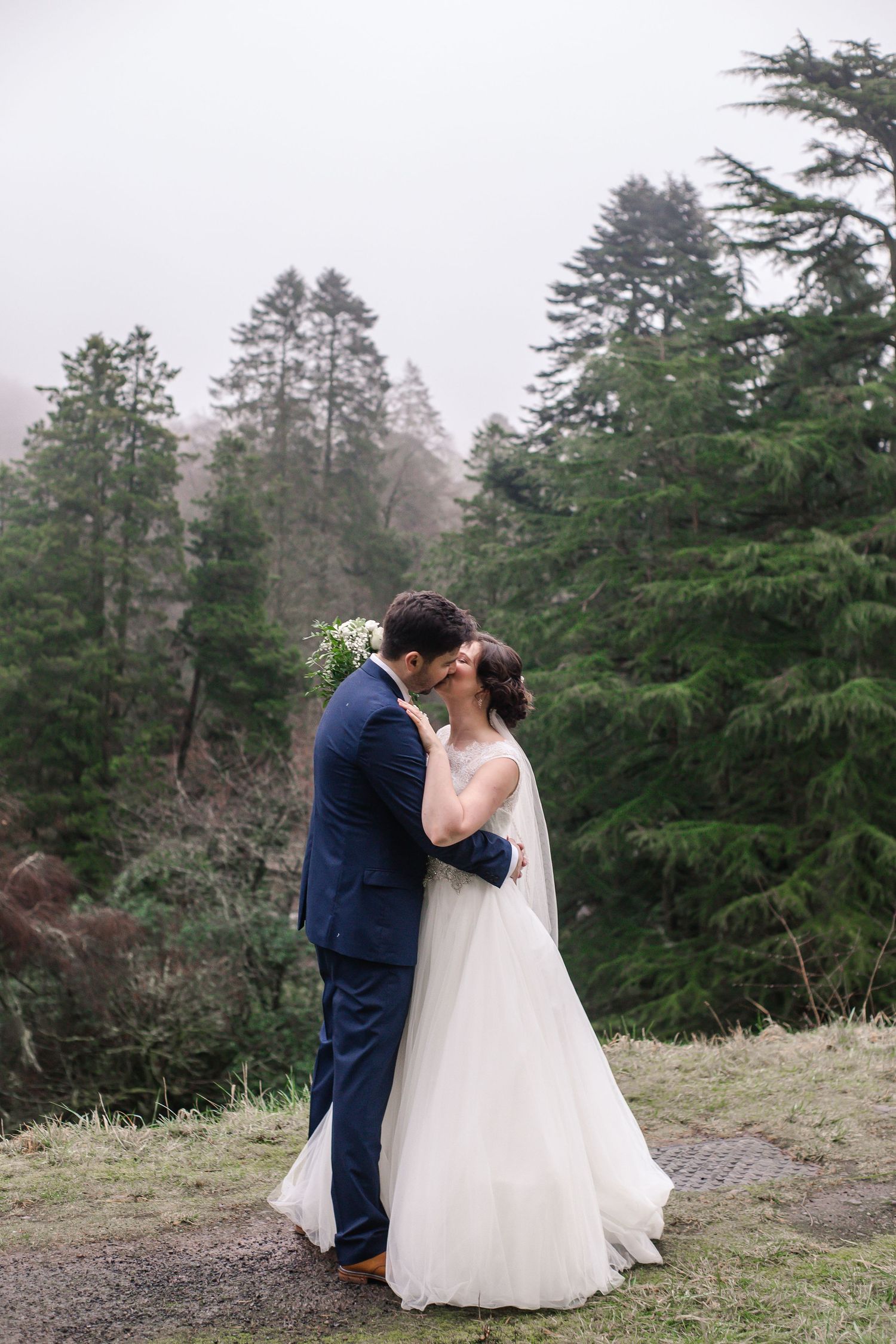 Bride and groom sharing a quiet kiss in the Craig y Nos Castle gardens