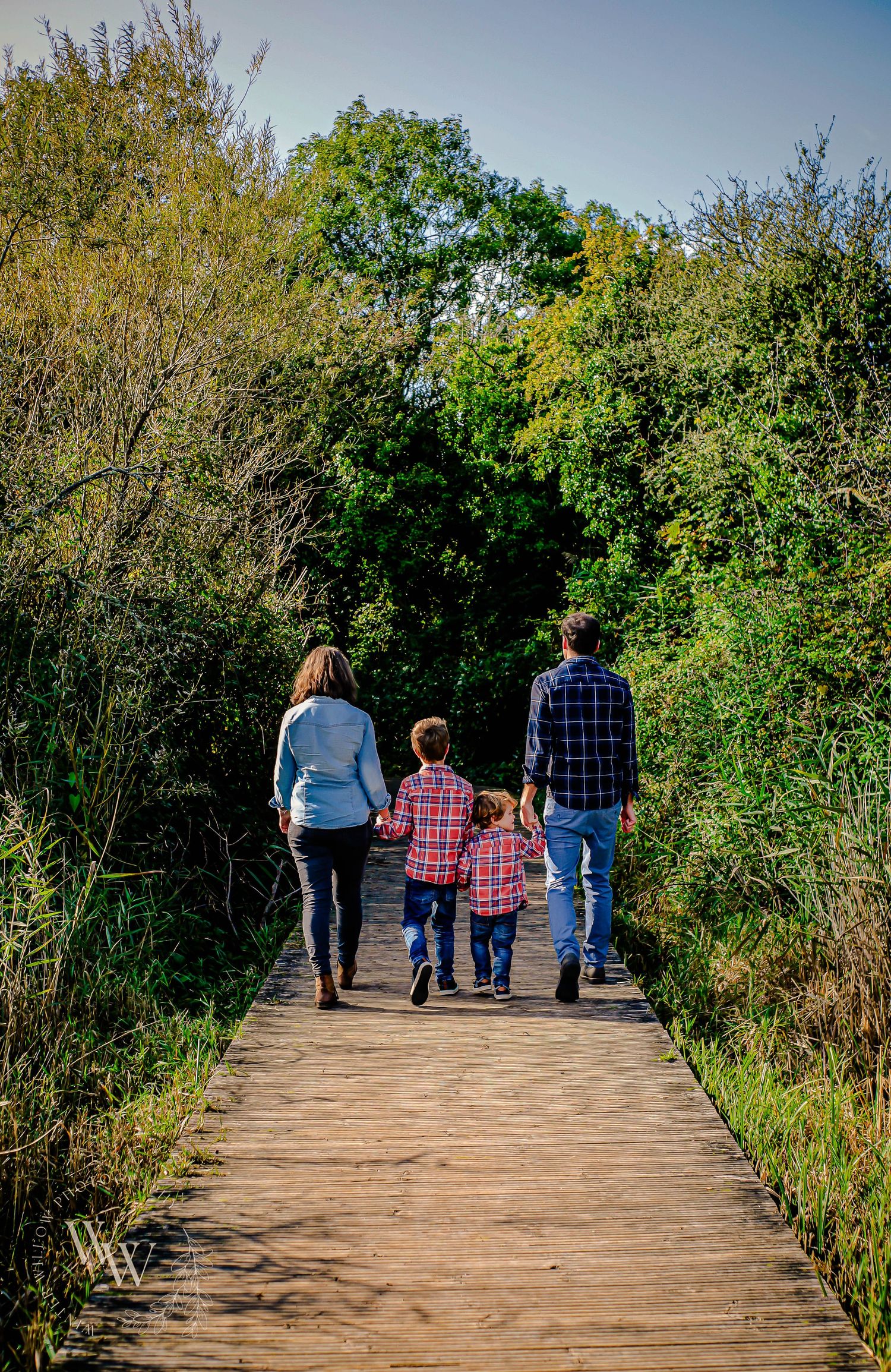 Family walking away together along a wooden boardwalk at Cosmeston Lakes