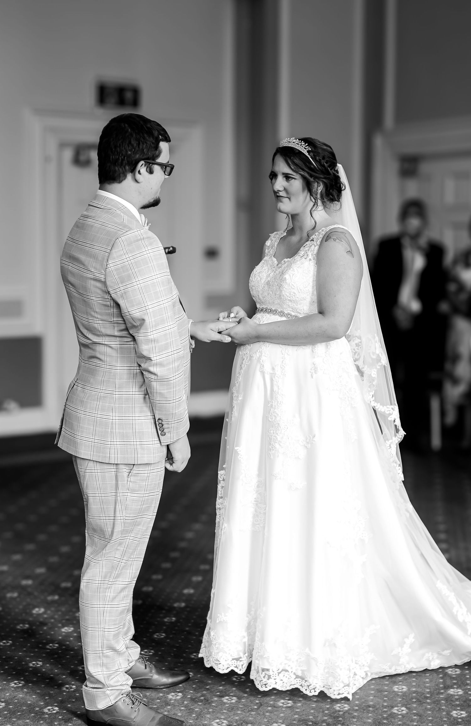 Black-and-white photograph of the couple exchanging rings