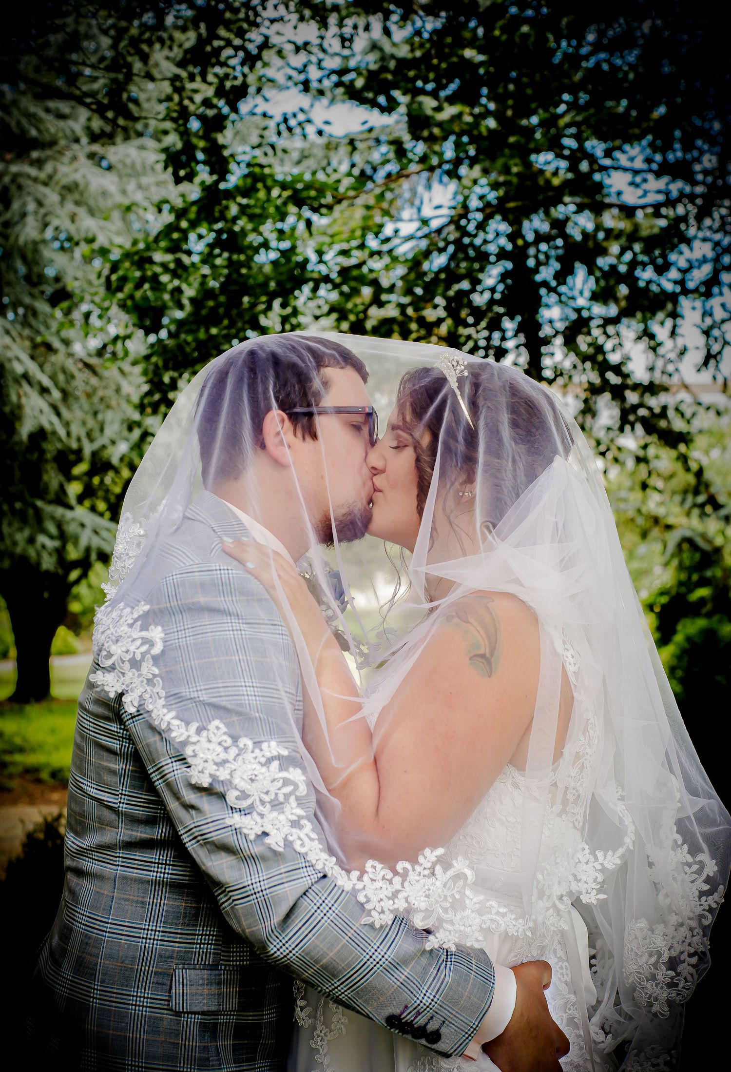 Bride and groom sharing a kiss beneath the wedding veil