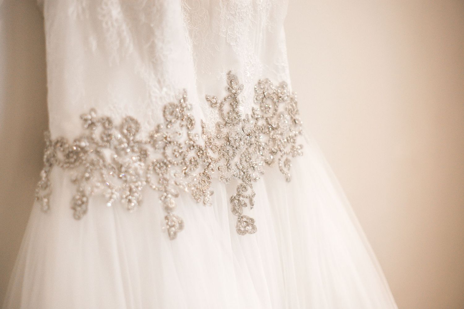 Close-up of the jewelled detailing on the bride’s wedding dress