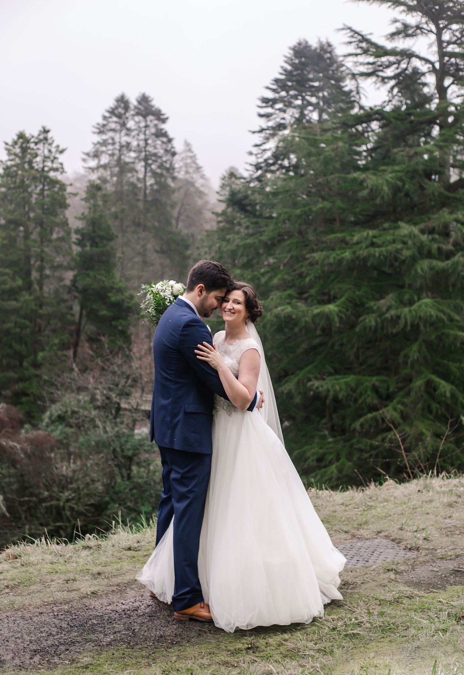 Bride and groom sharing a quiet kiss in the Craig y Nos Castle gardens
