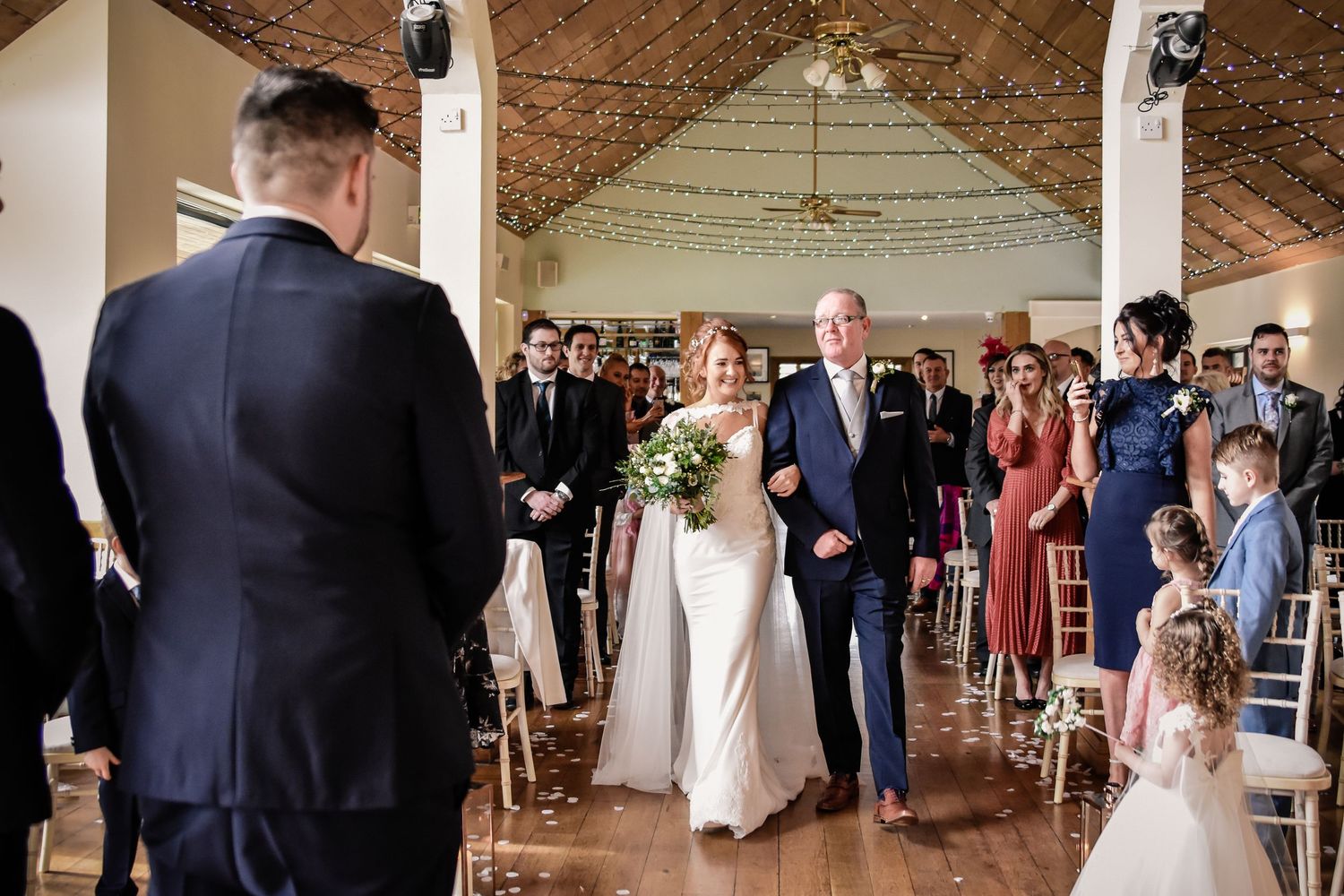 Bride arriving at the indoor Canada Lodge ceremony with her father