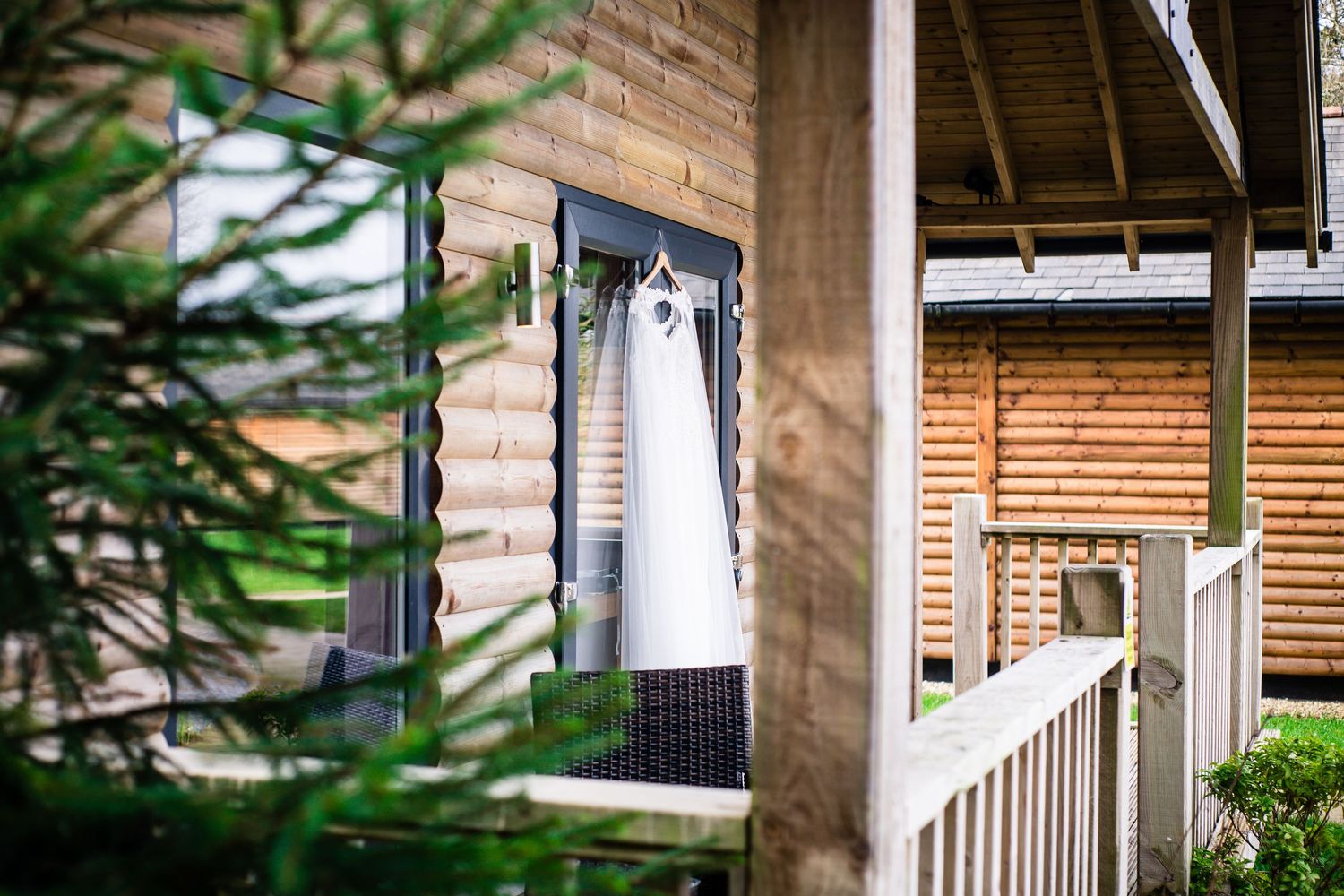 Wedding dress hanging outside a rustic woodland cabin