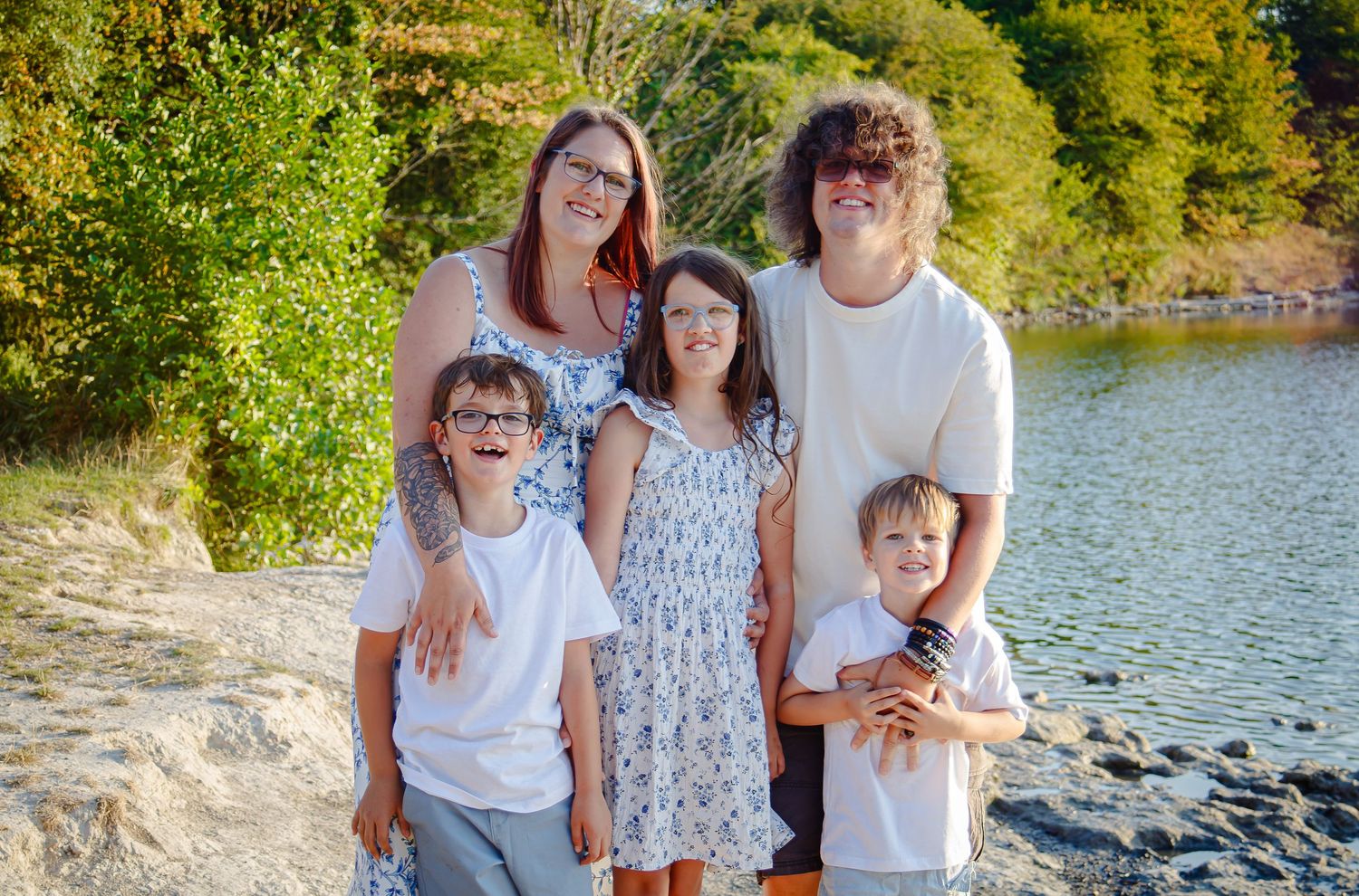 Family of five smiling together beside Cosmeston Lake in Penarth
