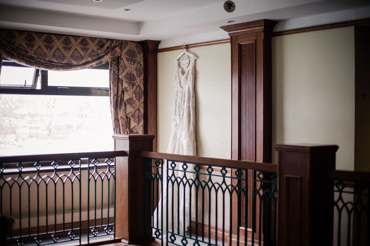 Wedding dress hanging beside the wooden staircase at Pencoed House, Bridgend