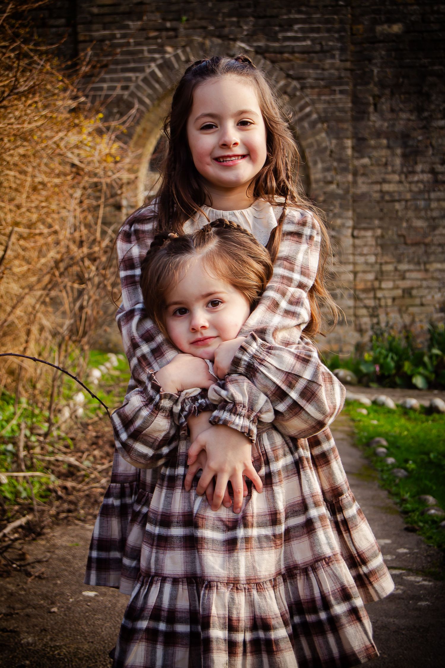 Older sister embracing her younger sister during their family session
