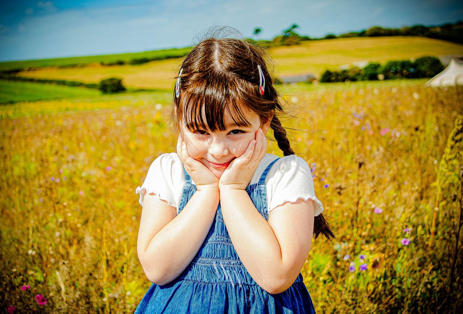 Young girl posing playfully in a colourful wildflower field