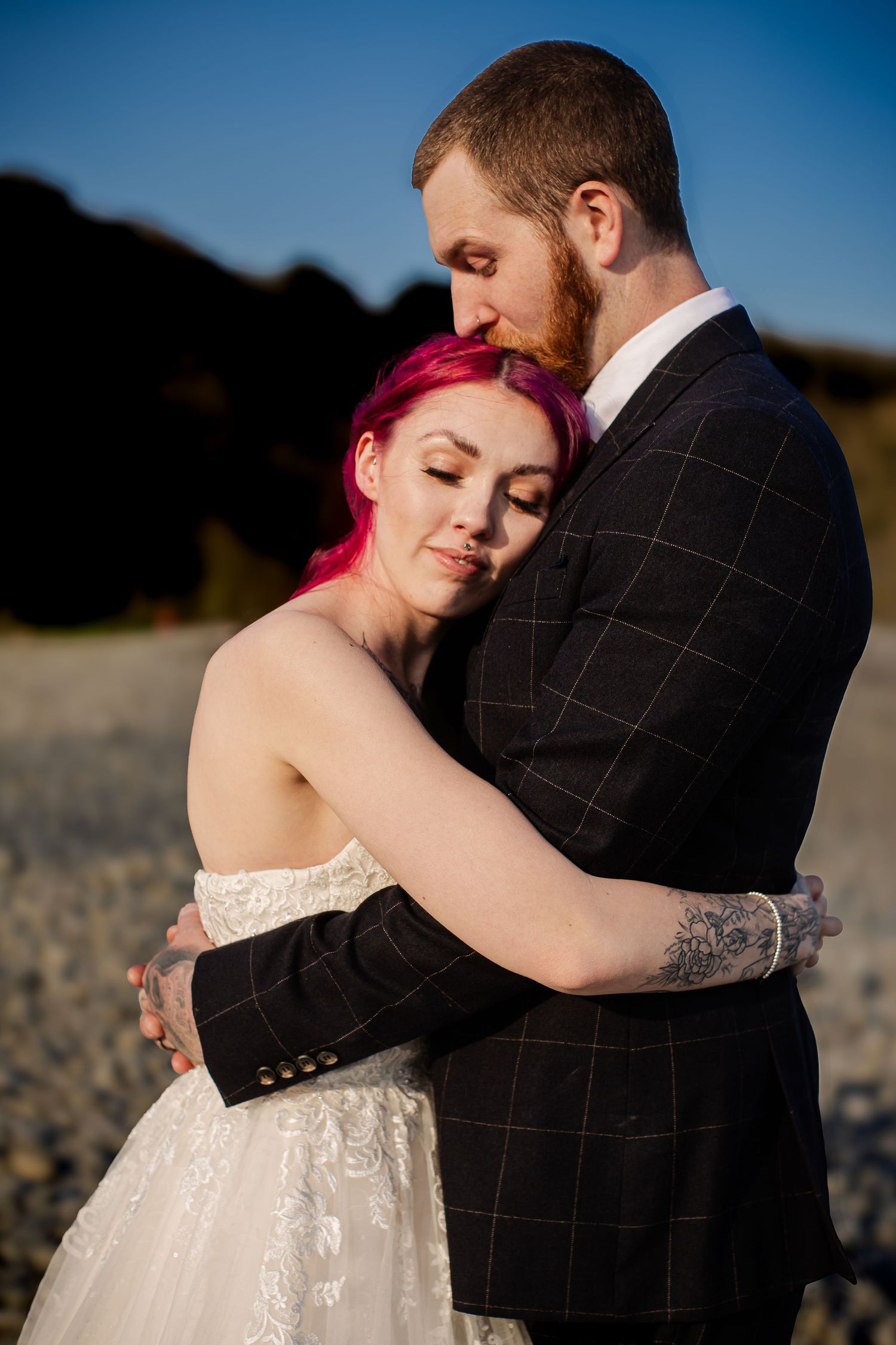 Bride resting against the groom during their beach wedding portraits