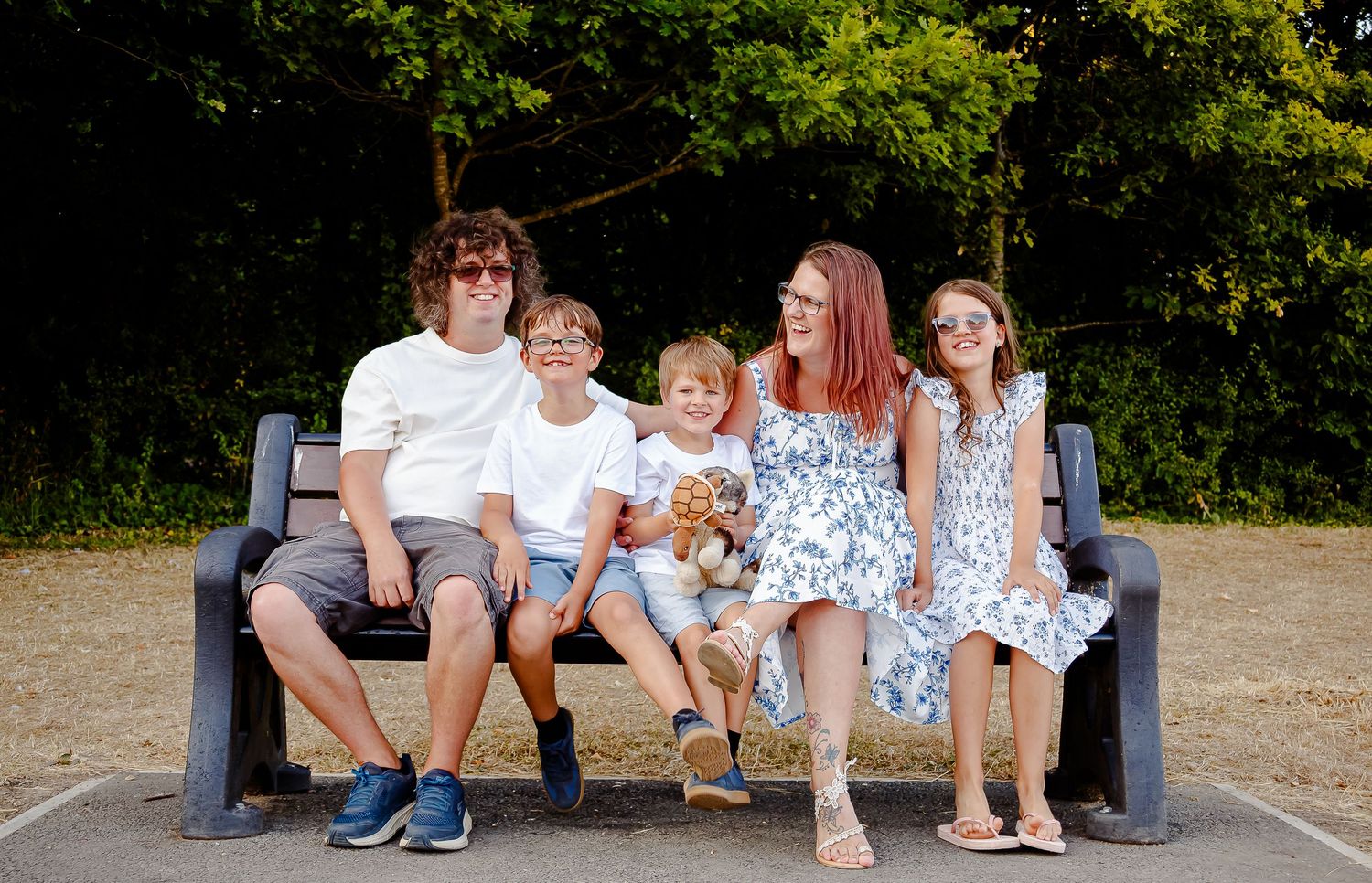 Relaxed family portrait on a bench during a Cosmeston Lakes photoshoot