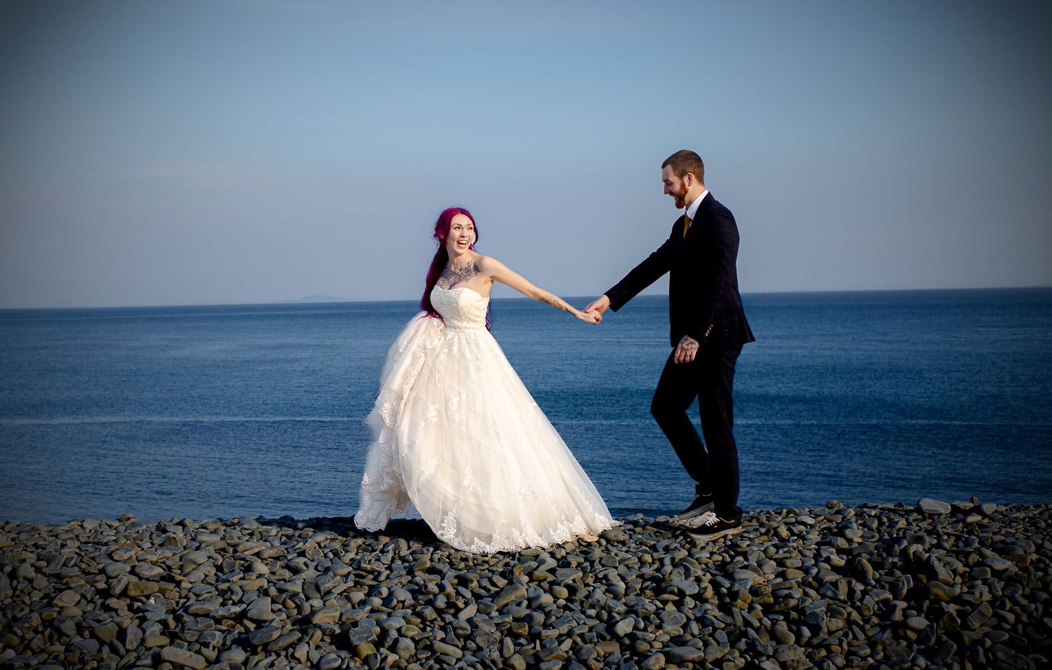Bride and groom standing together on Porthkerry pebble beach