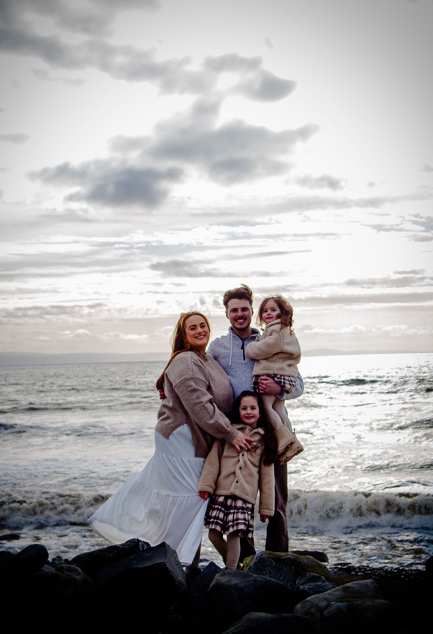 Family embracing on the rocky beach at Southerndown