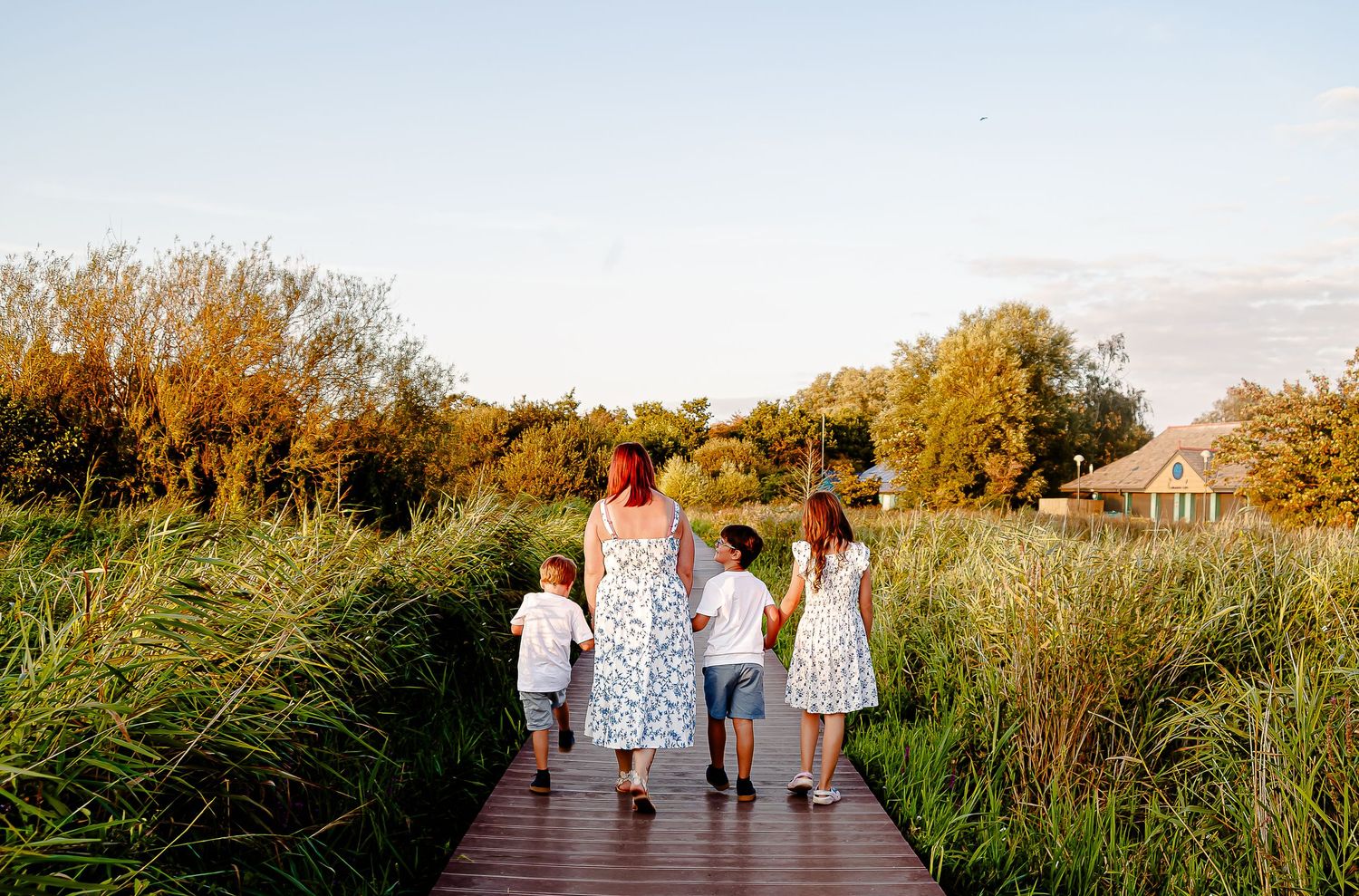 Family walking away together along the Cosmeston Lakes boardwalk