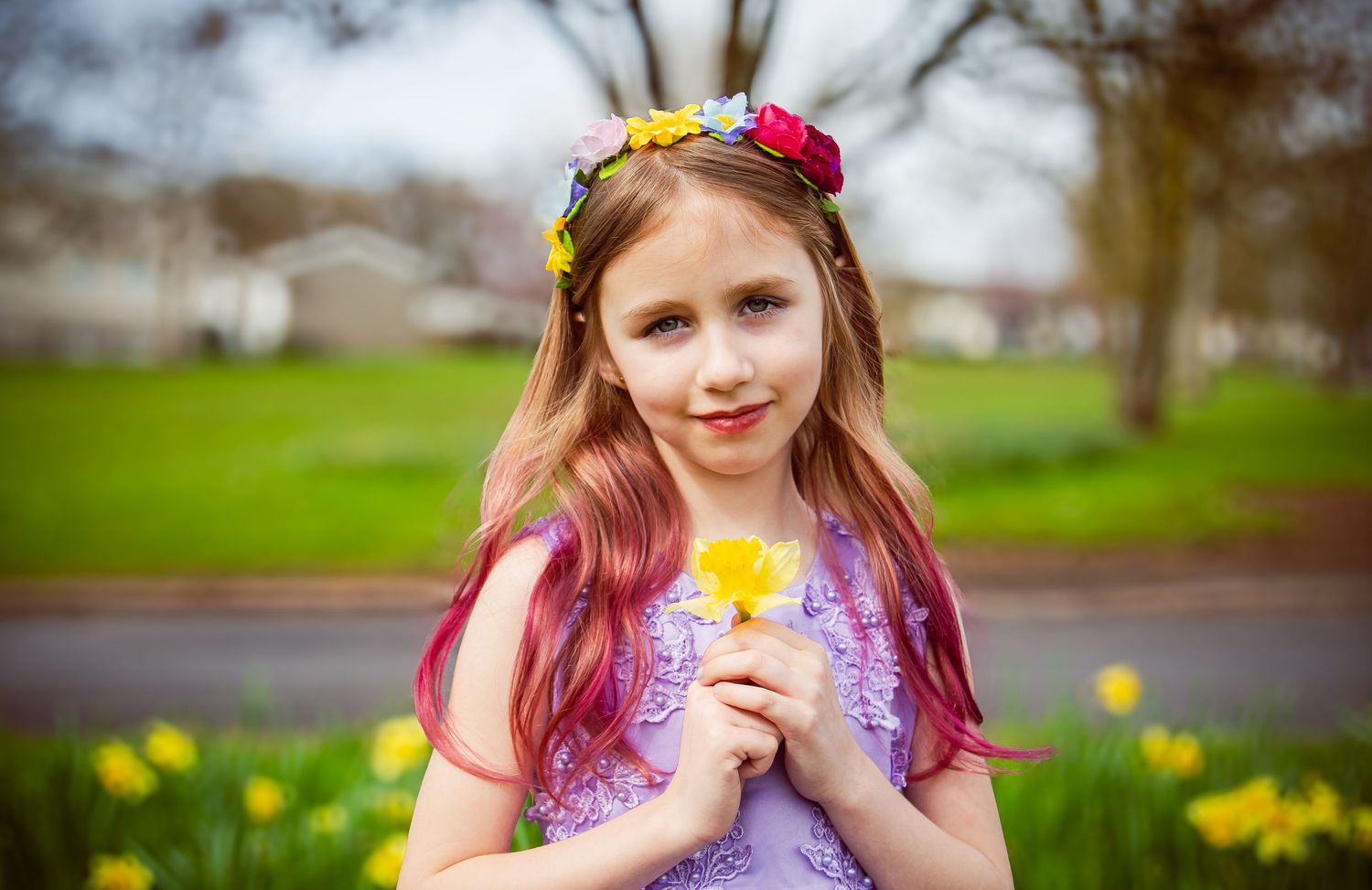 Girl wearing a flower crown and holding a yellow daffodil