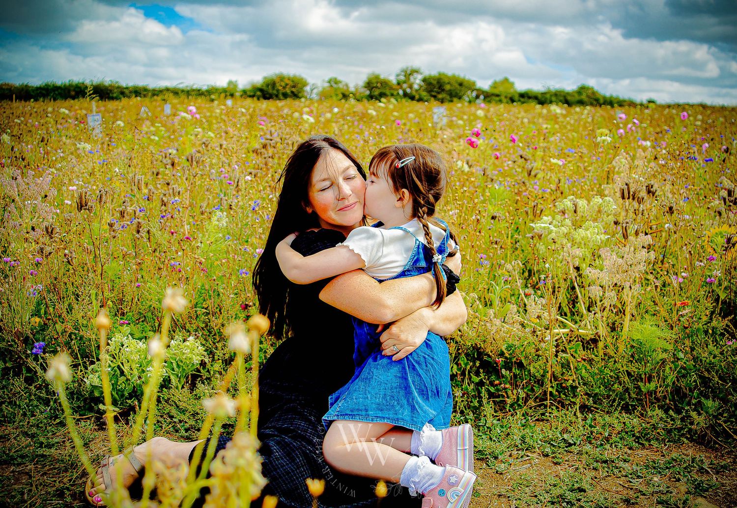 Mother cuddling her daughter during a relaxed family photoshoot at Rosedew Farm