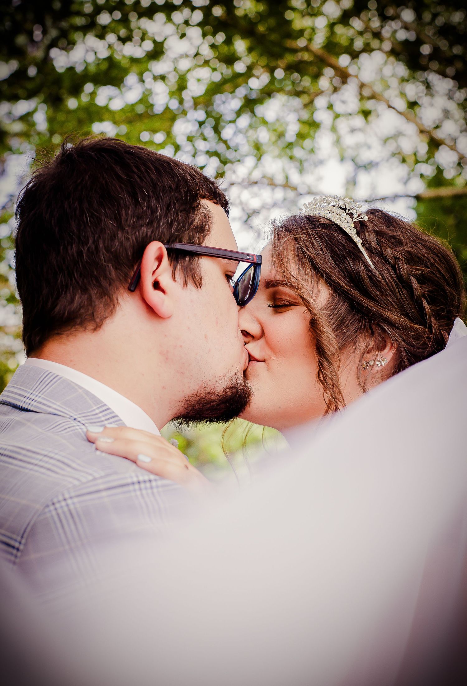 Bride and groom kissing in a softly framed wedding portrait
