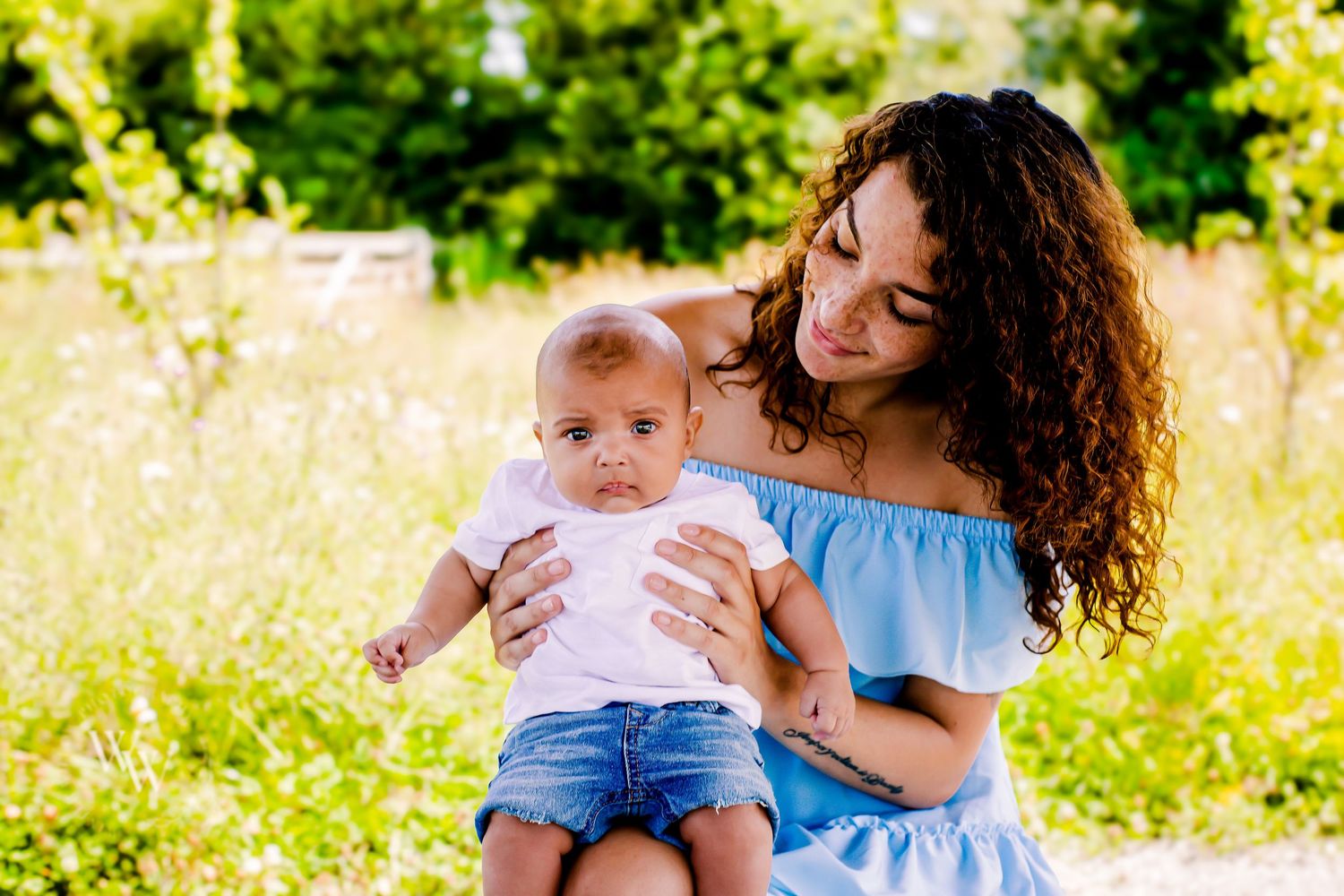 Mother smiling down at her baby during an outdoor family session at Cosmeston Lake, Penarth