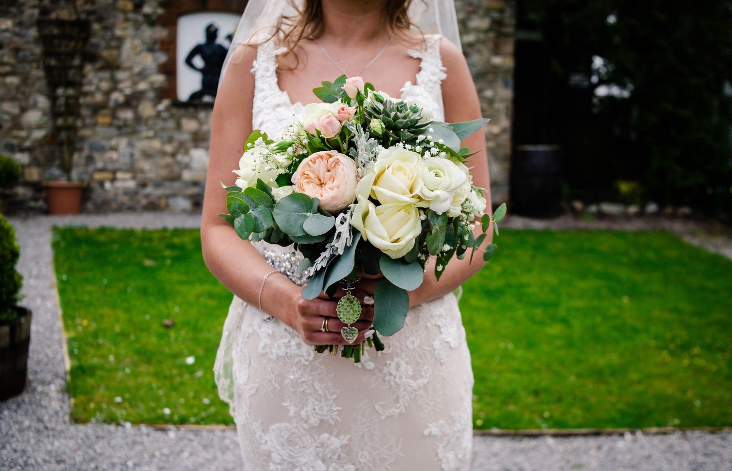 Close-up of the bride holding a cream, blush and blue wedding bouquet
