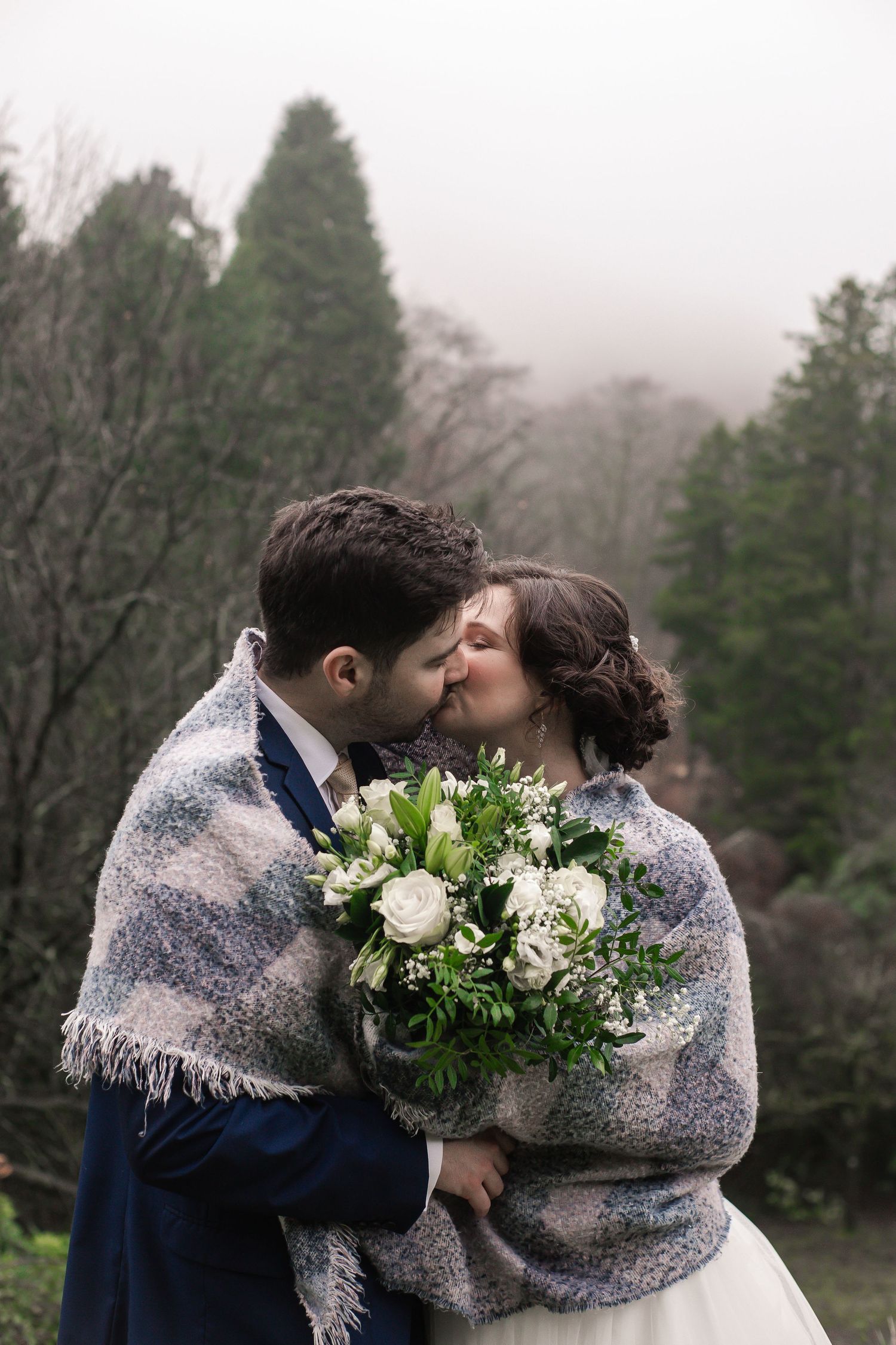 Bride and groom sharing a quiet kiss in the Craig y Nos Castle gardens