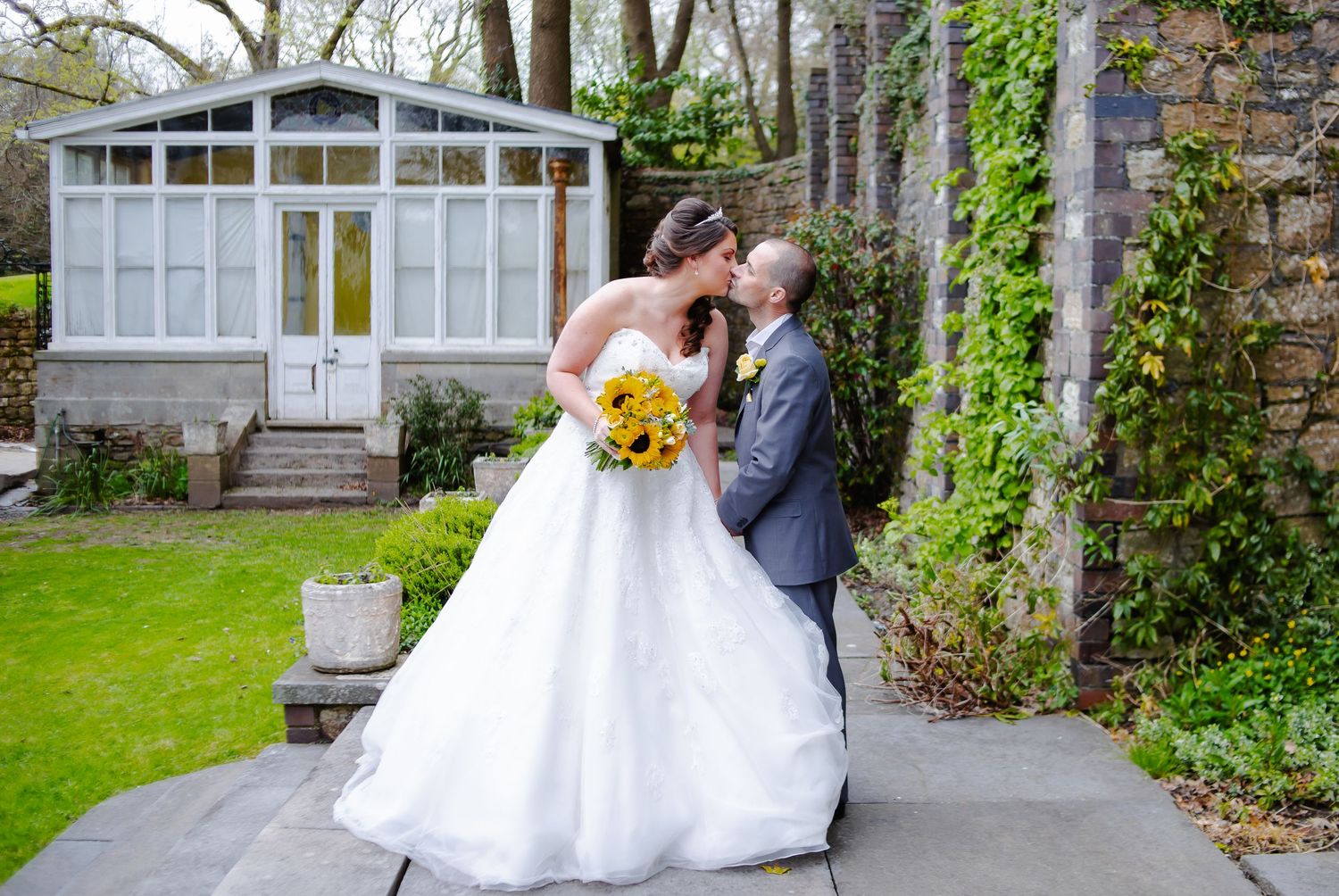 Bride and groom kissing with garden backdrop, Court Colmon, Bridgend