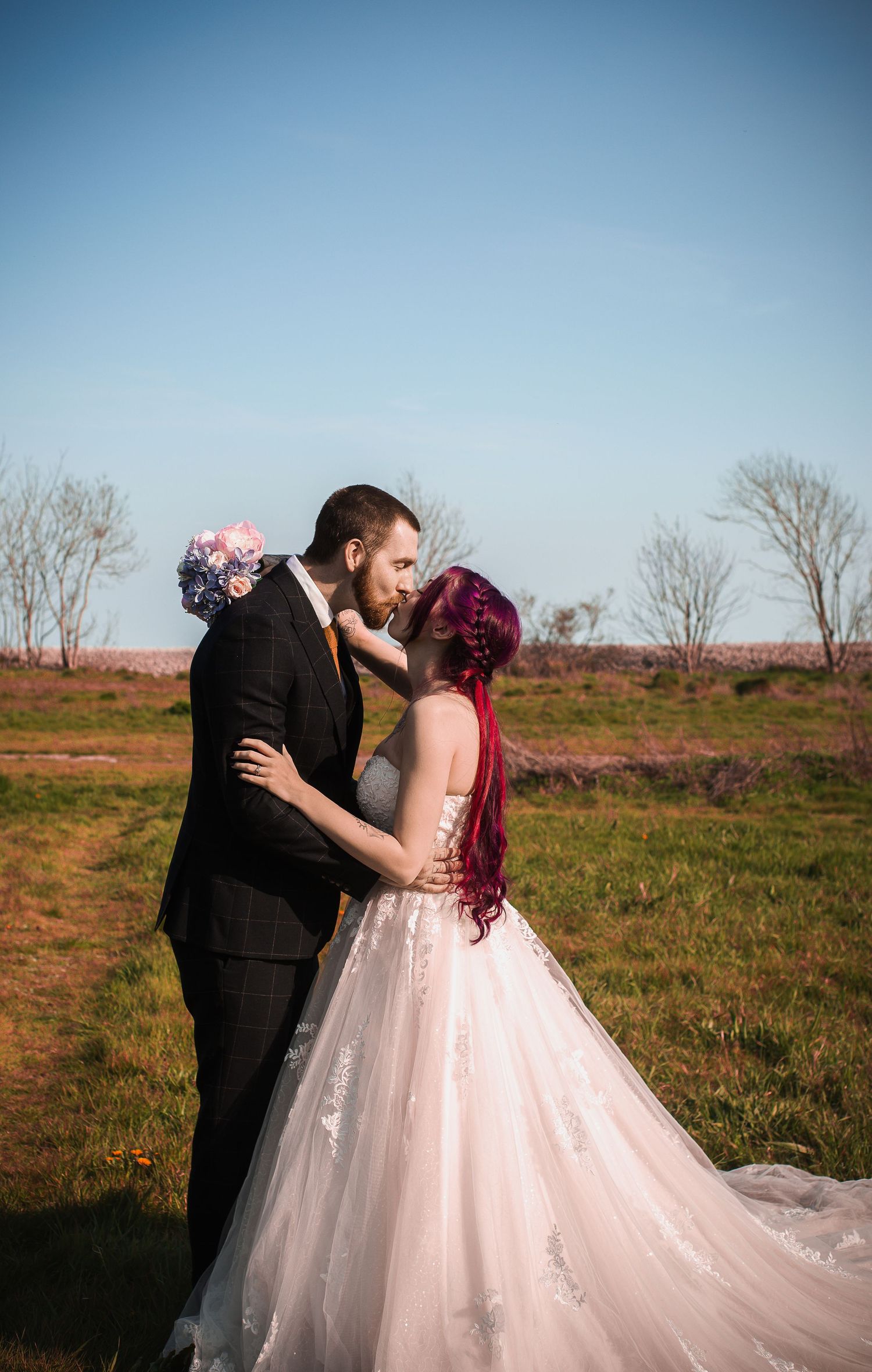 Groom kissing the bride’s forehead during their park portraits